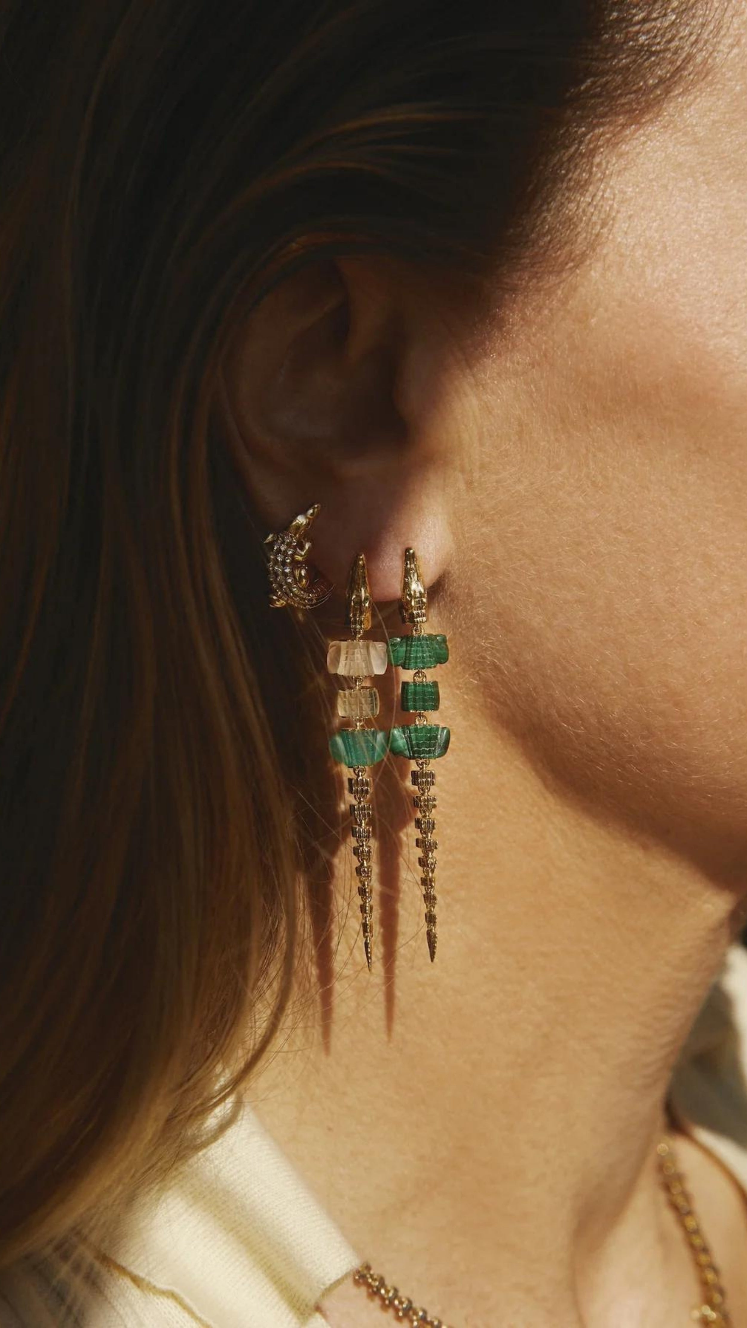 Bibi van der Velden Green Gradient Alligator Vertebrae Bite Earring. Crafted in 18K yellow gold, the alligator&#39;s body is formed by White Quartz, Green Amethyst, Green Agate while the head and tail are in solid 18K gold.  Photo shows earring on model.
