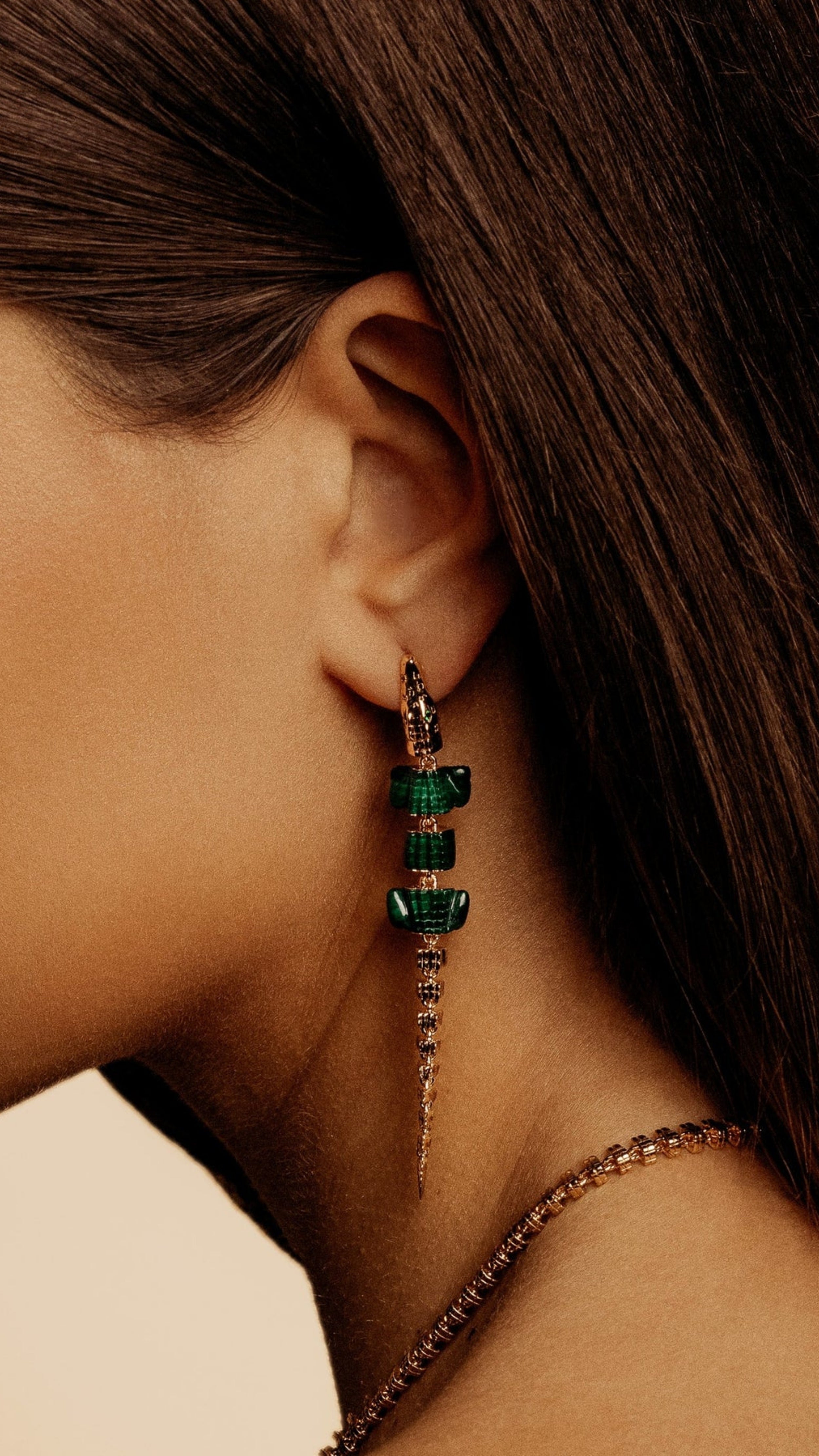 Bibi van der Velden Malachite Alligator Vertebrae Bite Single Earring. Hand-crafted 18K yellow gold earring with spine of the alligator and lifelike malachite body with Tsavorite accents. It has a unique bite clasp and moving tail. Shown on model.