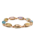 Bibi van der Velden Mini Scarab Eternity Bracelet. Made in 18k rose gold, this bracelet has nine  scarab beetles, each made with translucent, matte gemstones in soft shades. The beetles' heads are paved with pale brown diamonds. Shown from the side view.