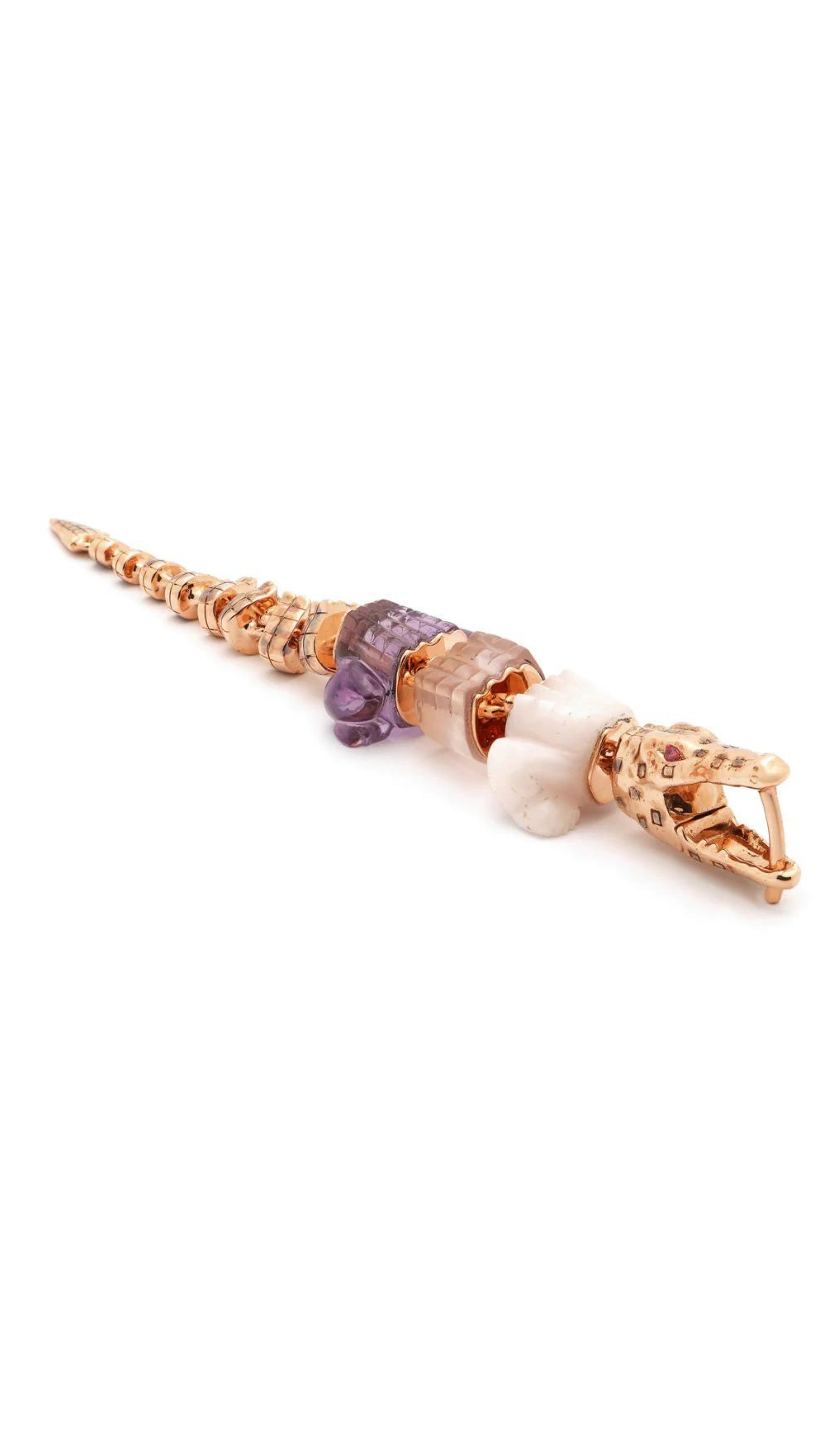 Bibi van der Velden Pink Gradient Alligator Vertebrae Bite Single Earring A single earring in the shape of an alligator made from 18K rose gold and rose quartz, amethyst, pink opal. It features sapphire eyes and the alligator body moves. Photo shows earring laying flat.