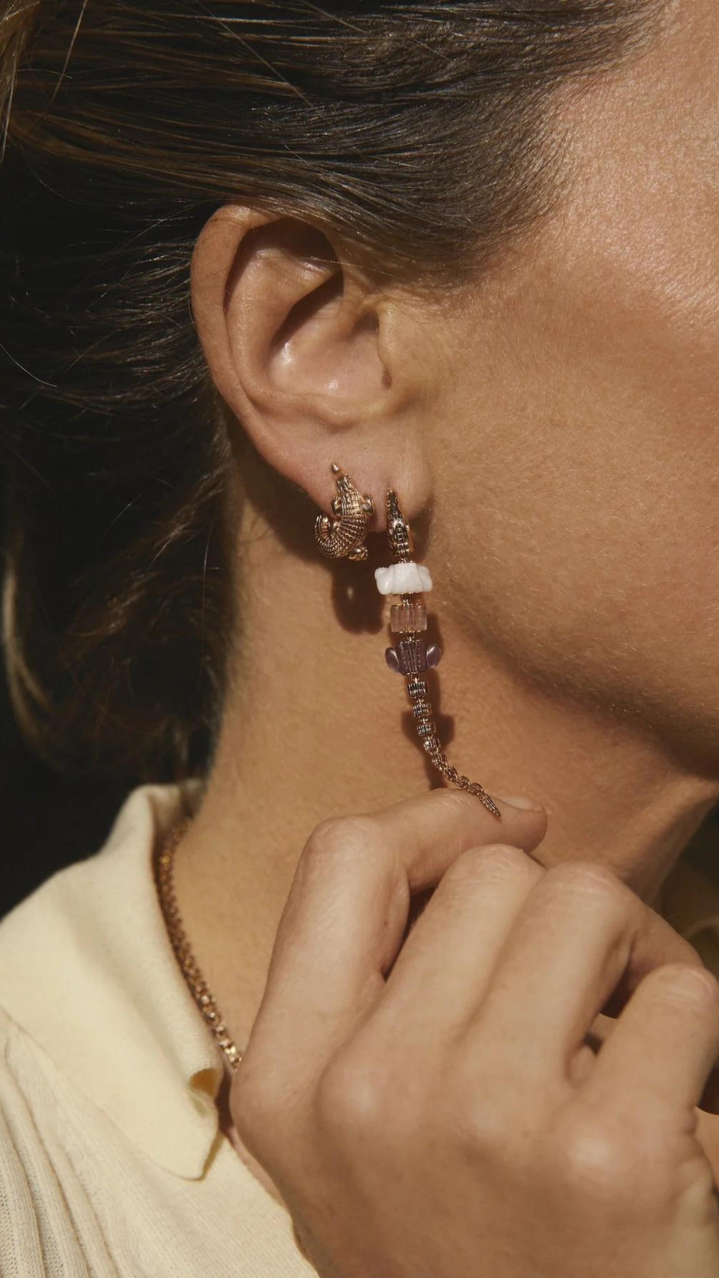 Bibi van der Velden Pink Gradient Alligator Vertebrae Bite Single Earring A single earring in the shape of an alligator made from 18K rose gold and rose quartz, amethyst, pink opal. It features sapphire eyes and the alligator body moves. Photo shows earring on a model.