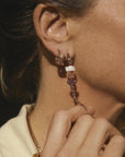 Bibi van der Velden Pink Gradient Alligator Vertebrae Bite Single Earring A single earring in the shape of an alligator made from 18K rose gold and rose quartz, amethyst, pink opal. It features sapphire eyes and the alligator body moves. Photo shows earring on a model.
