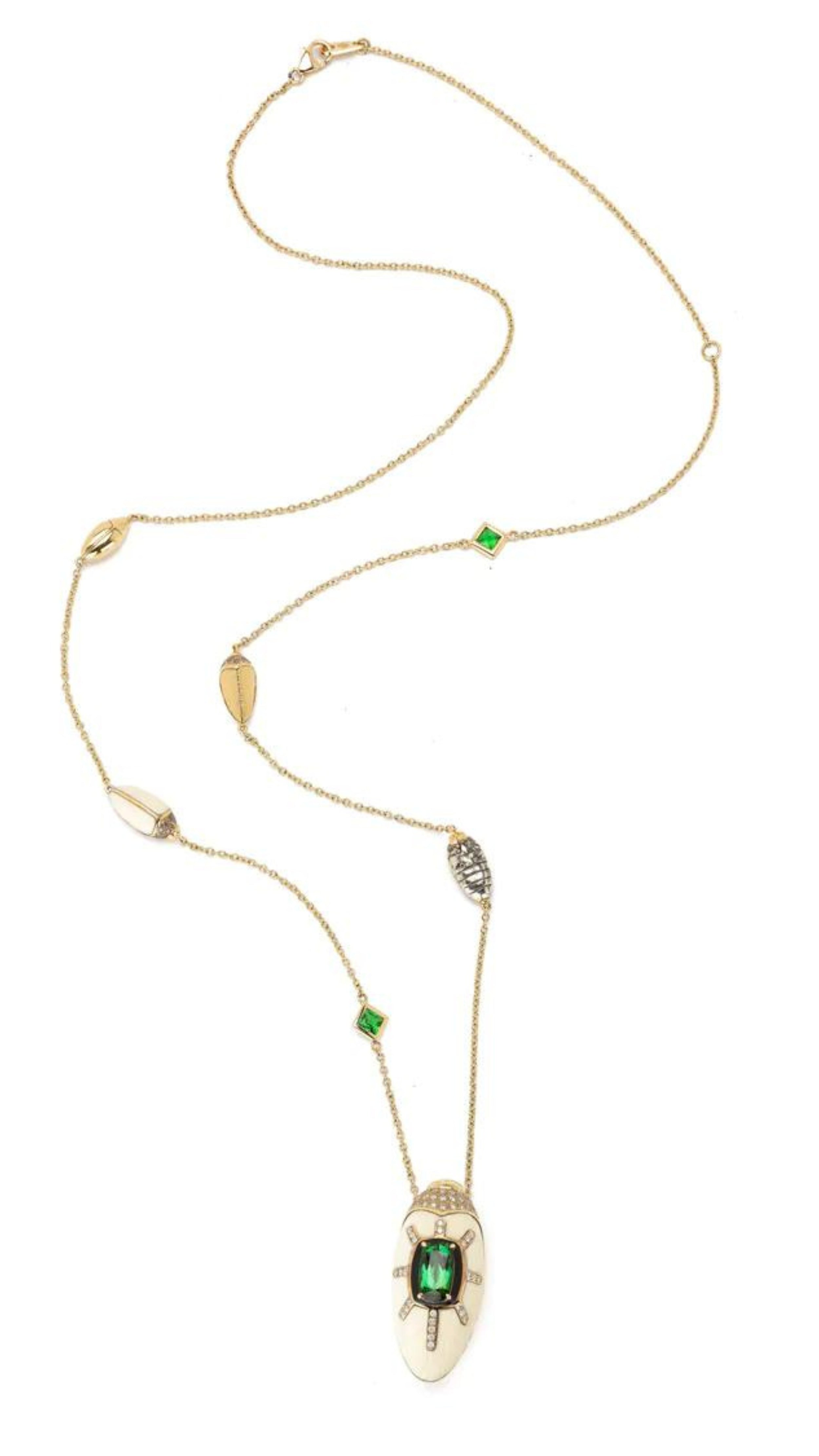 Bibi van der Velden Scarab Mammoth Necklace. Art deco style scarab pendant drop crafted from mammoth tusk and set with green tsavorite stones and pave white and brown diamonds. With links in the chain of scarabs and inset stones. Adjustable length necklace. Sustainable high jewelry. Photo showing the entire length of necklace from the front.