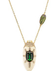Bibi van der Velden Scarab Mammoth Necklace. Art deco style scarab pendant drop crafted from mammoth tusk and set with green tsavorite stones and pave white and brown diamonds. With links in the chain of scarabs and inset stones. Adjustable length necklace. Sustainable high jewelry. Photo showing a close up on the scarab pendent.