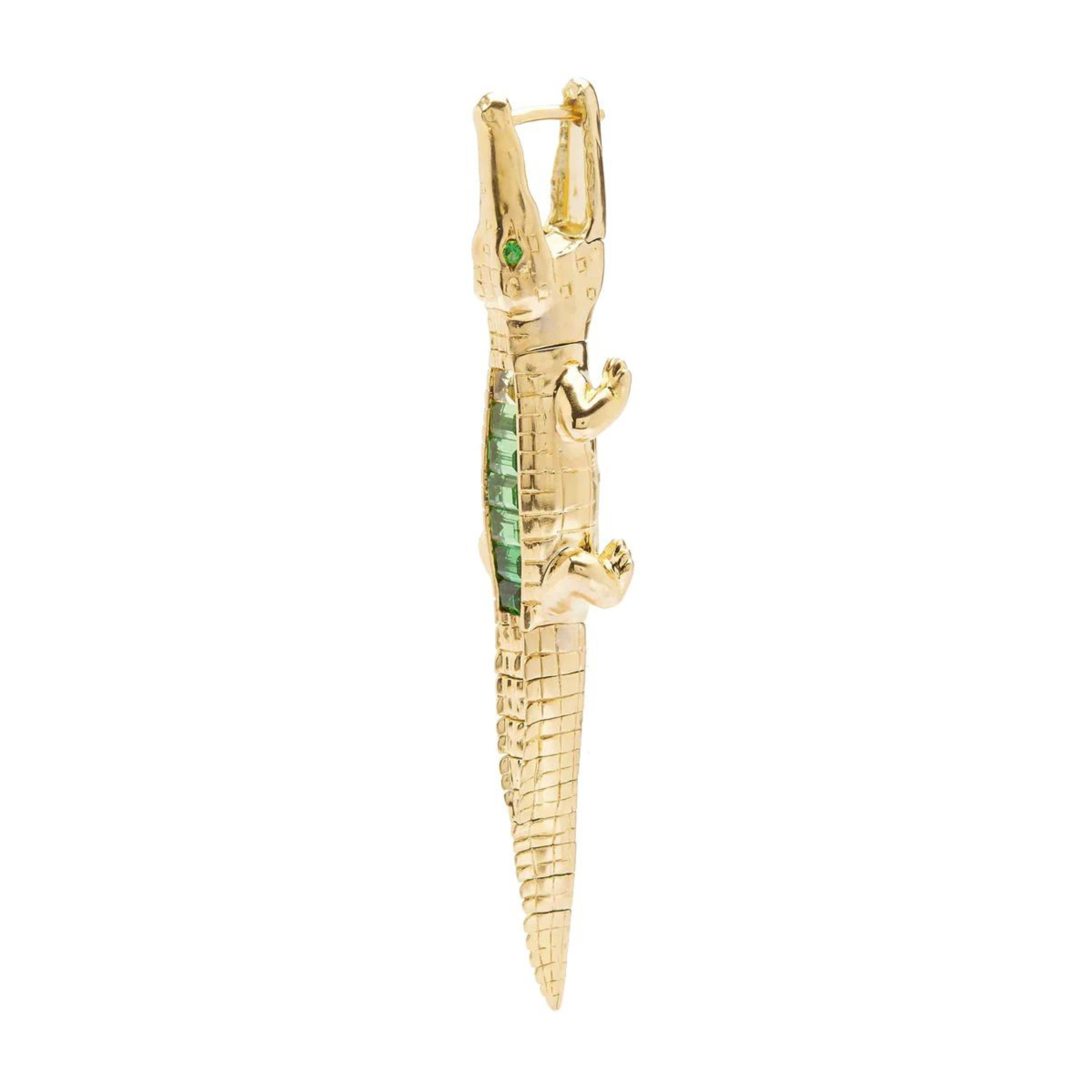 Bibi ven der Velden, Tsavorite Alligator Ear Bite Earring  Crafted in 18K yellow gold and featuring an arrangement of green tsavorites, the intricately carved design replicates an alligator's body. Shown from the side.