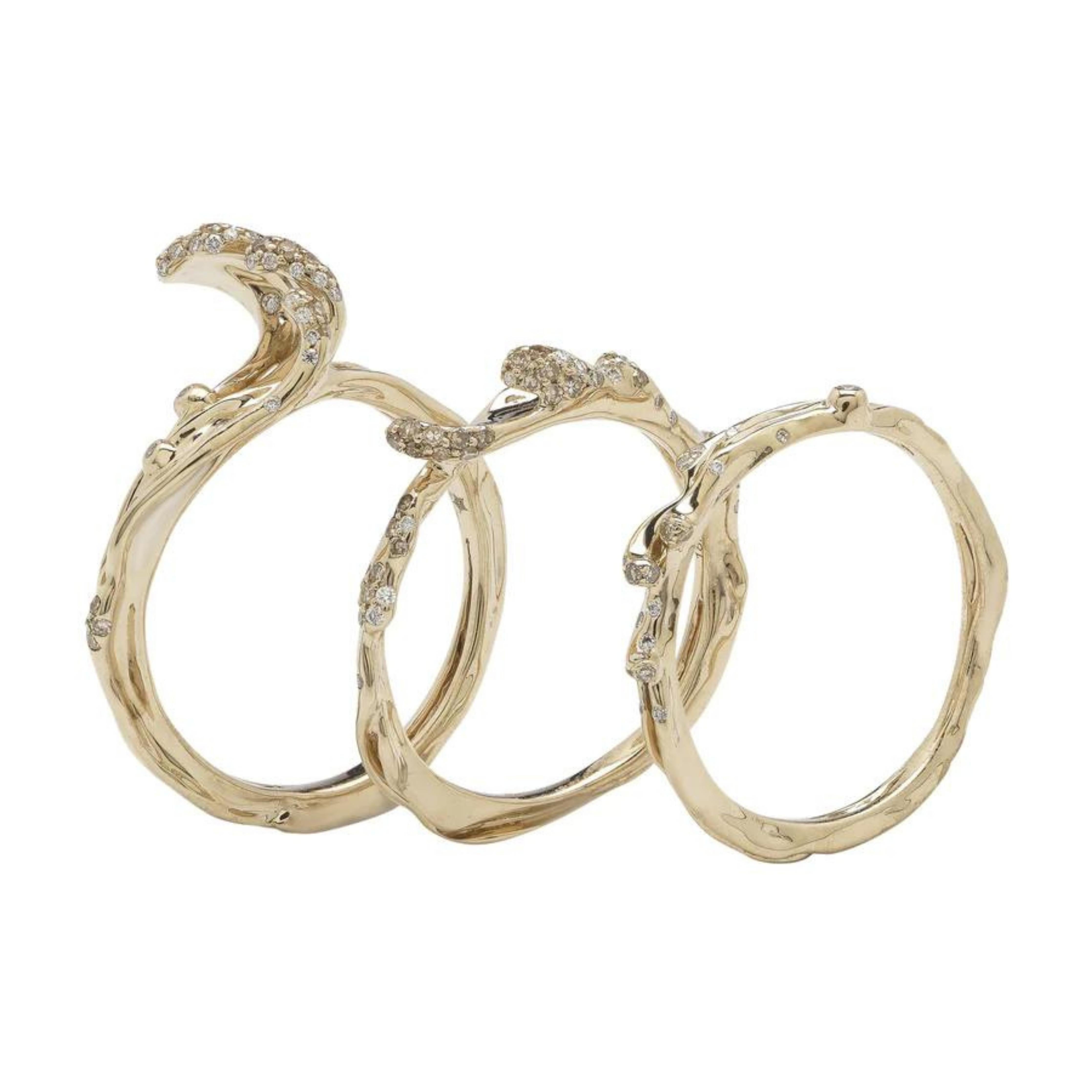 Wave Stackable Rings are three rings that can be snapped together to be worn as one piece, or purchased and worn as individual rings. Designed in pure 18k white gold, which has a slightly yellow tone, the rings are set with light brown and white diamonds. Shown with other stackable wave rings.