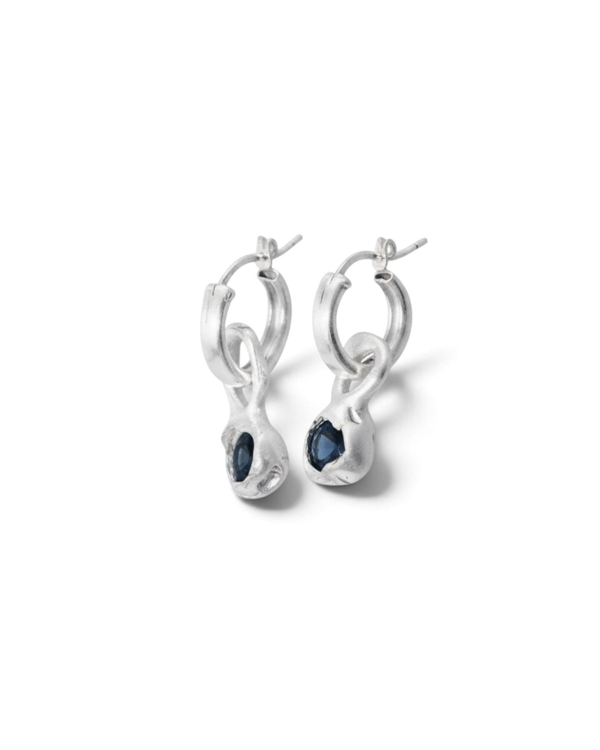 Sterling silver hoop earrings with blue topaz drops, side view on white background