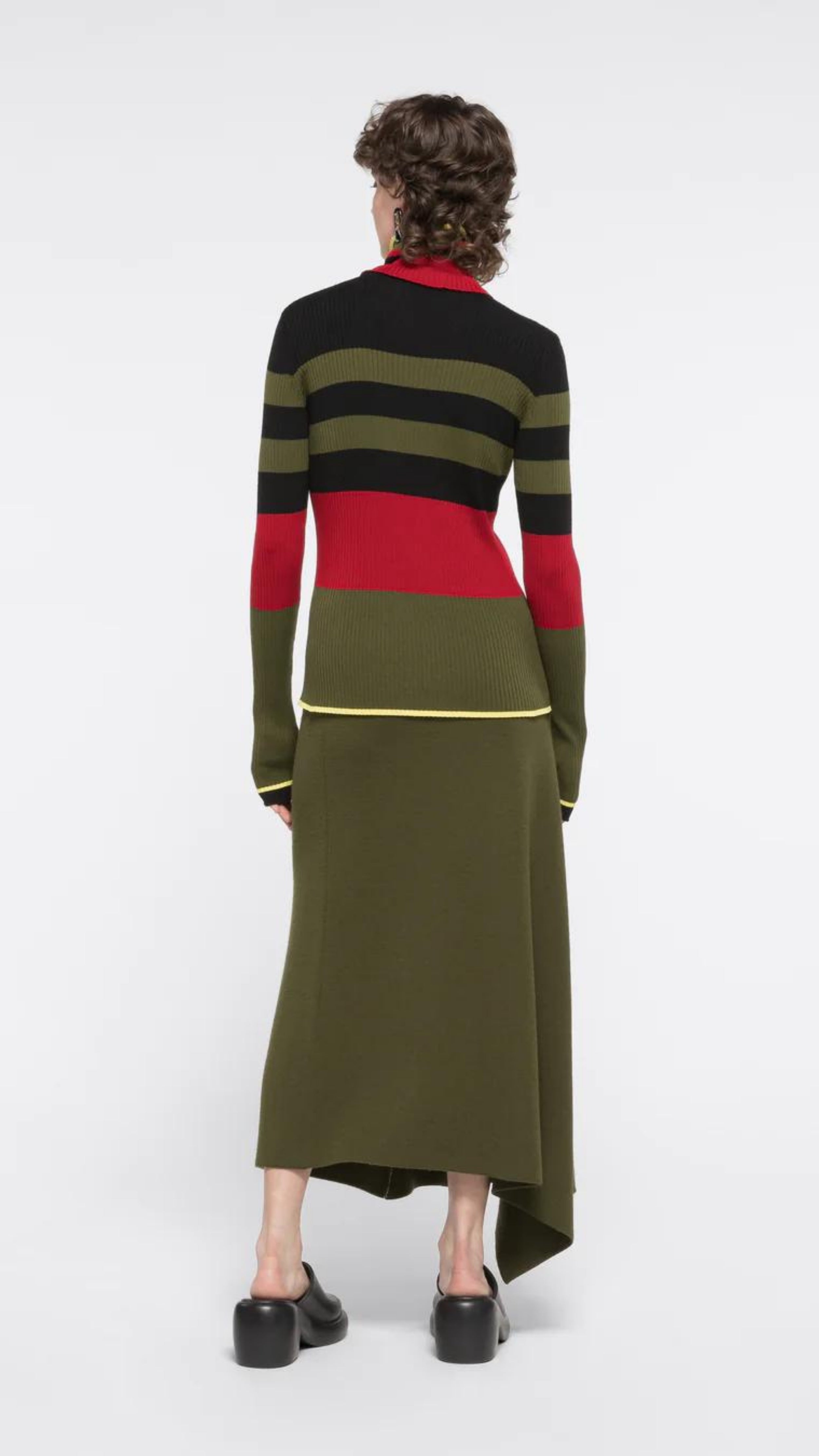 Colville AZ Factory Molly Molloy and Lucinda Chambers, Color Block Crewneck Sweater with Snood. Long sleeve sweater with crew neckline in varying stripes of black, olive and red with high light of yellow at bottom hem and cuffs. Shown on Model facing back.