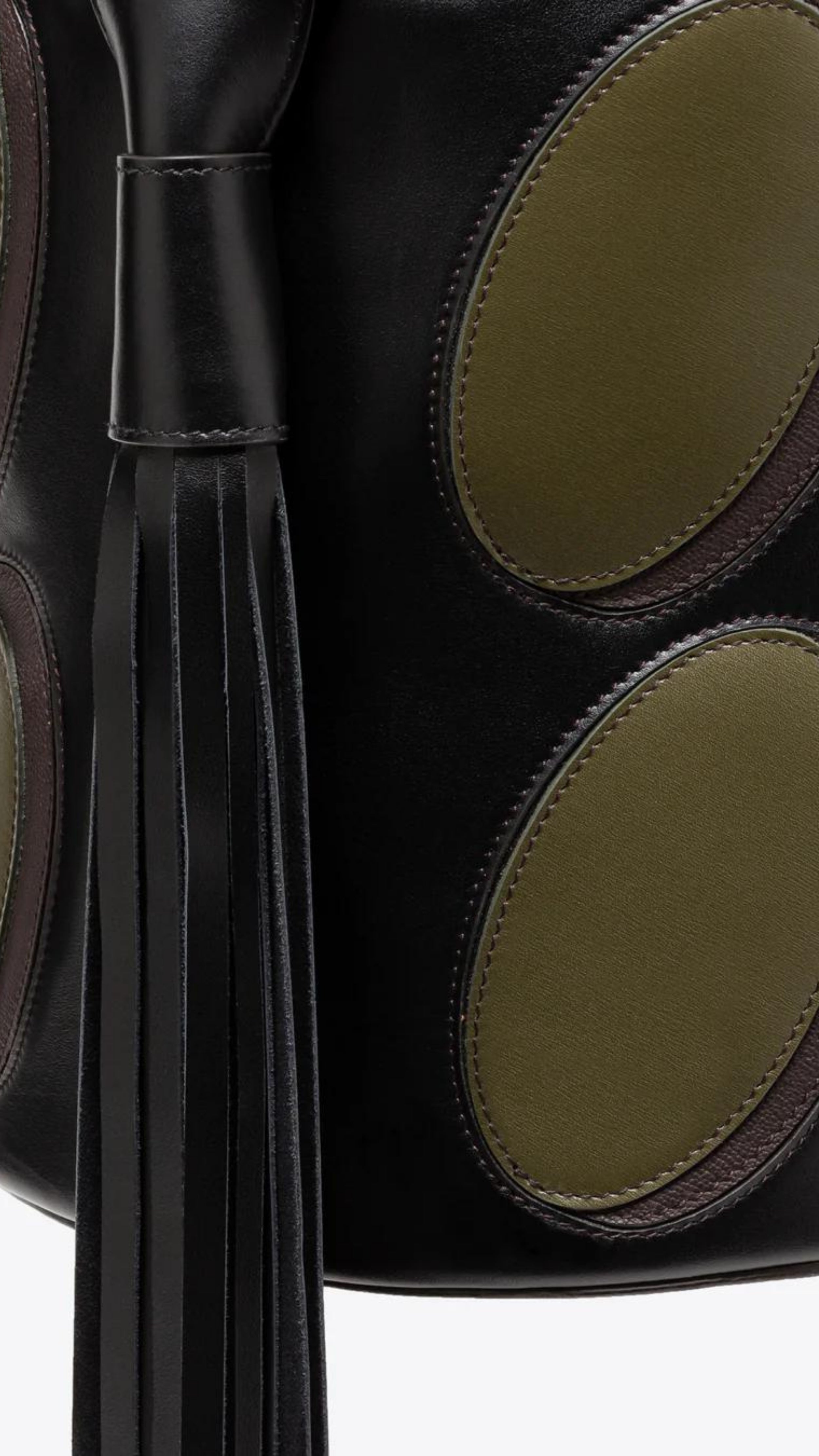AZ Factory Colville Molly Molloy Lucinda Chambers,  Leather Patchwork Midi Bucket Bag.. Black oval bucket back in black leather with olive green ovals patches. Has an adjustable black handle and a dramatic oversize black leather tassel. Close up of oval olive green leather patchwork and tassel.