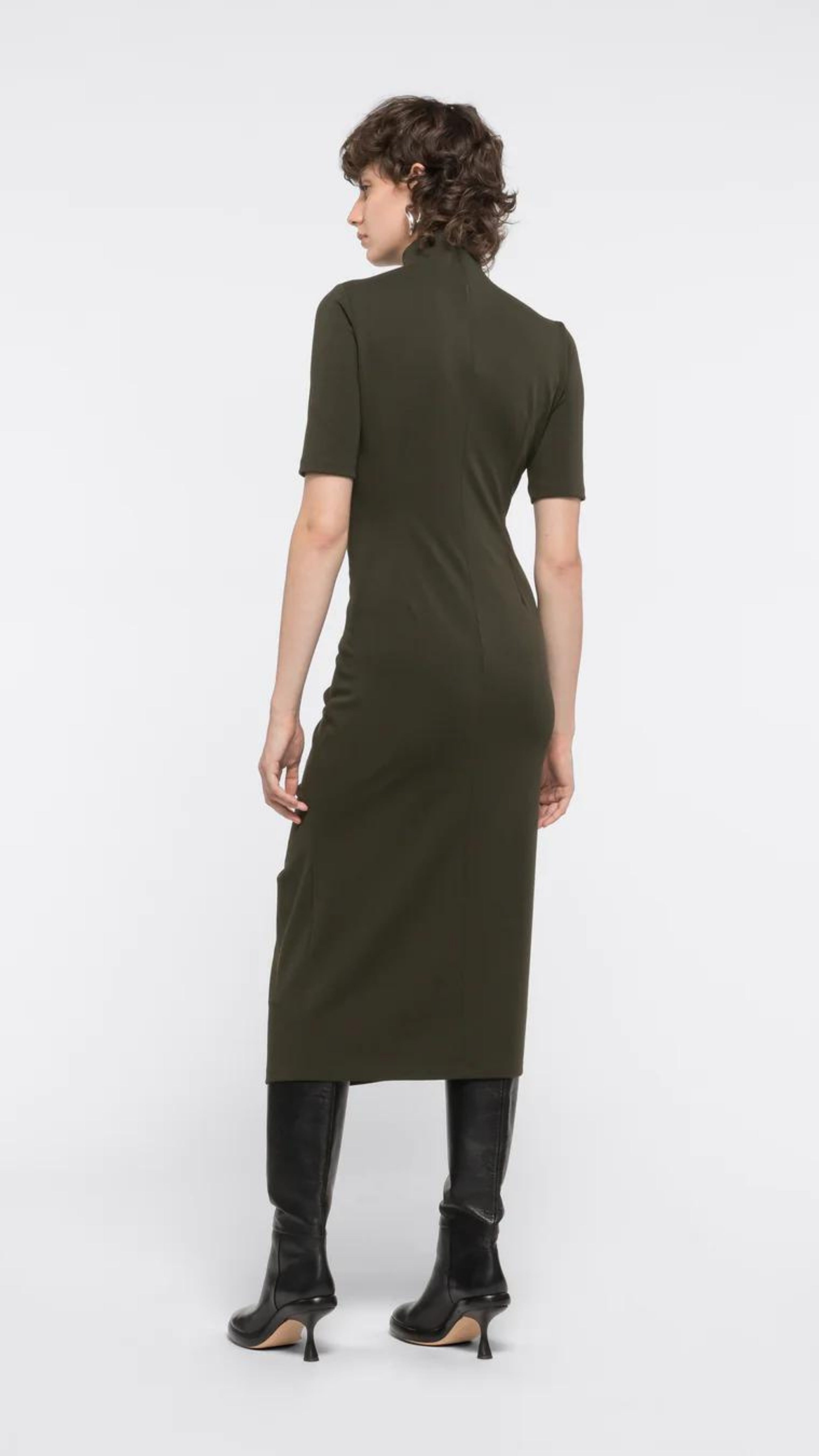 AZ Factory Colville Molly Molloy Lucinda Chambers, Ruffled Turtle Neck Dress A ruffled turtle neck dress. It is fitted with a loose T-neckline, ruffling up the front center and short sleeves. This dress has a midi length hemline.  Shown on model facing the back.