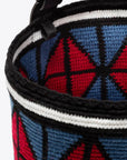 AZ Factory Colville Molly Molloy Lucinda Chambers, Woven Midi Bag  The woven midi bag is woven in Wayuu Colombian and finished with Italian leather craftsmanship. This mid-sized purse features a unique diamond pattern in ruby red and blue, contrasted by black leather detailing, a long adjustable strap, and a ruby interior pouch. Detail of weaving and colors