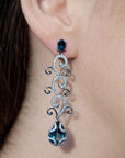 Conde de diamante Eden Earrings. 18K white gold drop earrings  Featuring a London Blue Topaz stud and tendrils of white gold with pave white diamonds and a second London Blue Topz Drop at the bottom. Shown on model.