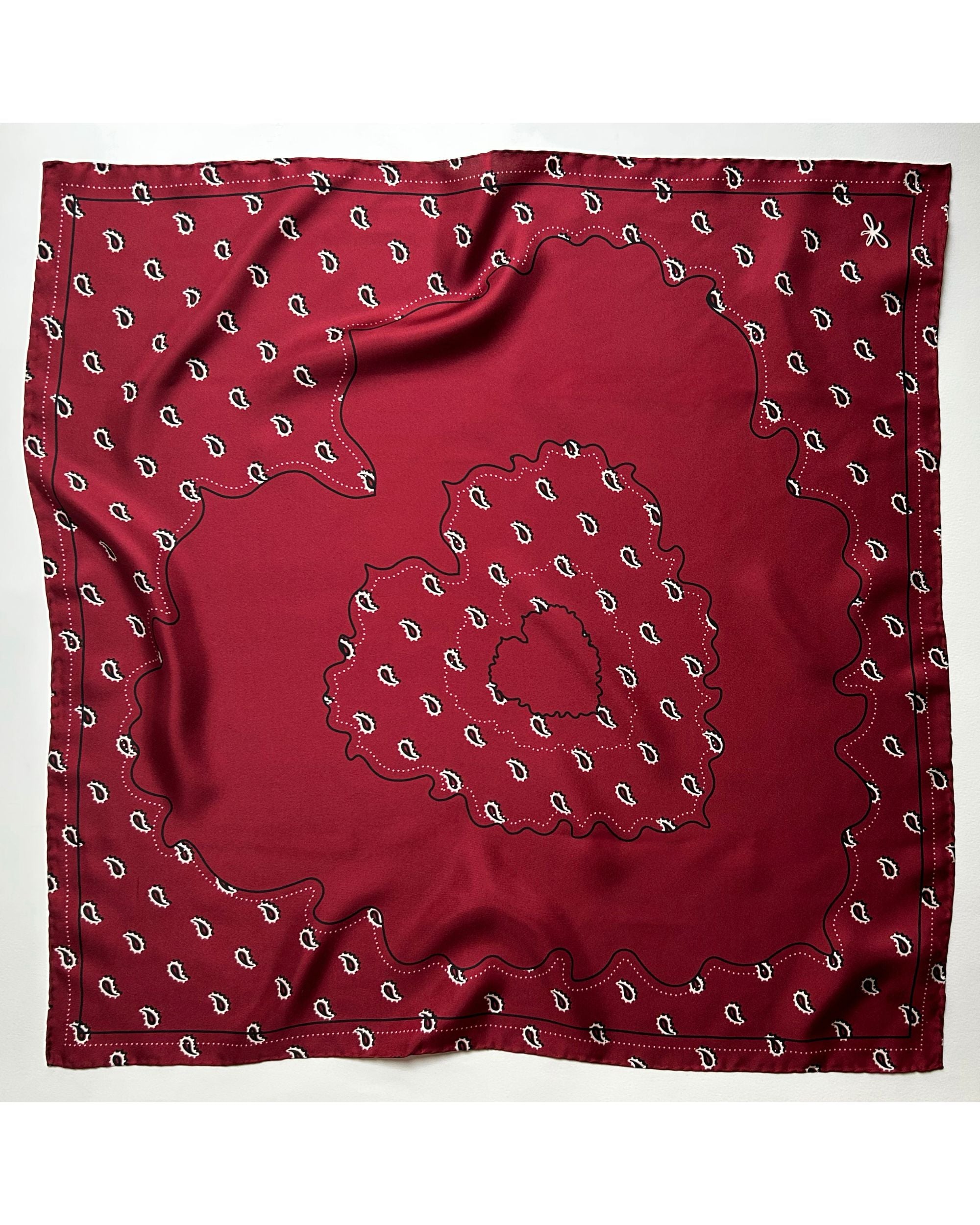Red silk scarf tied with paisley motif

