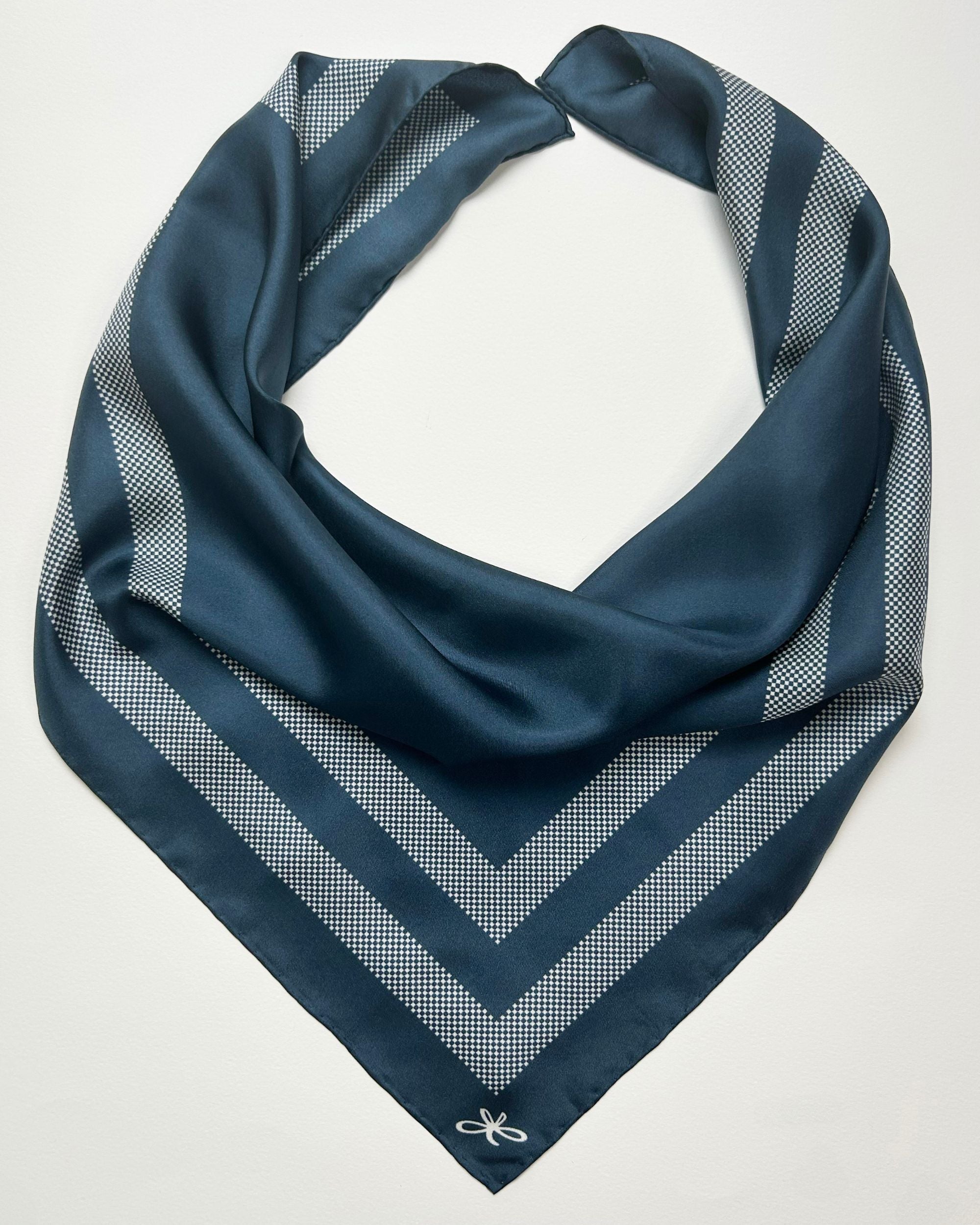 Square blue silk scarf laid flat showing border design