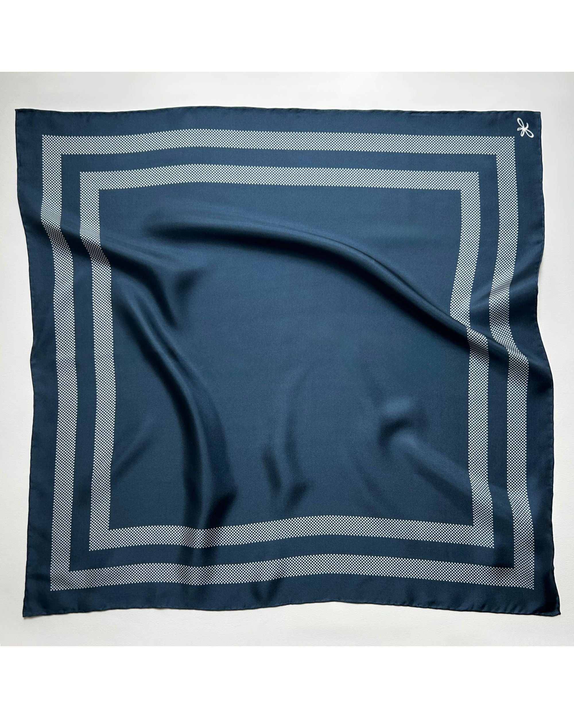 Square blue silk scarf laid flat showing border design