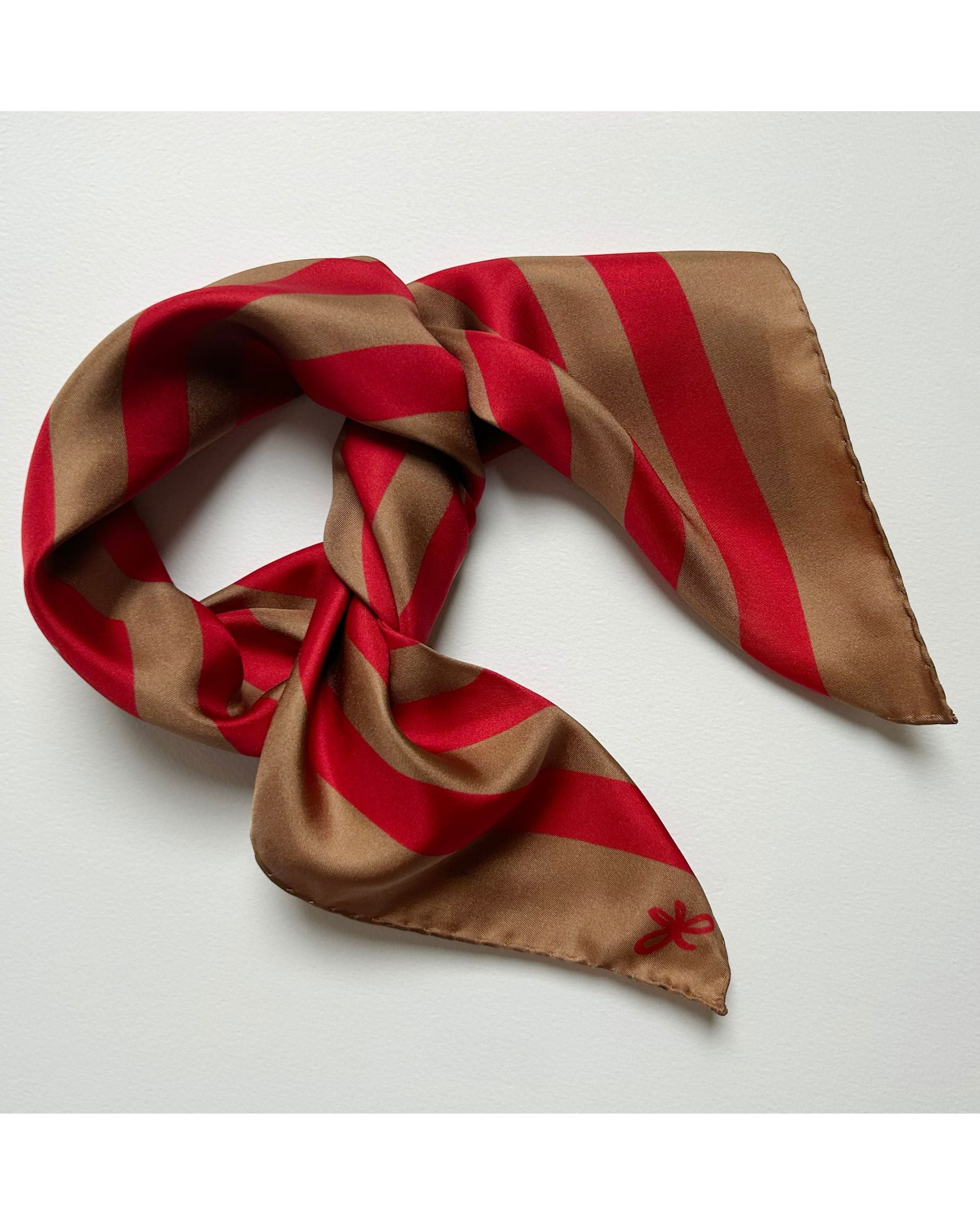 Red and beige striped silk scarf tied in a knot
