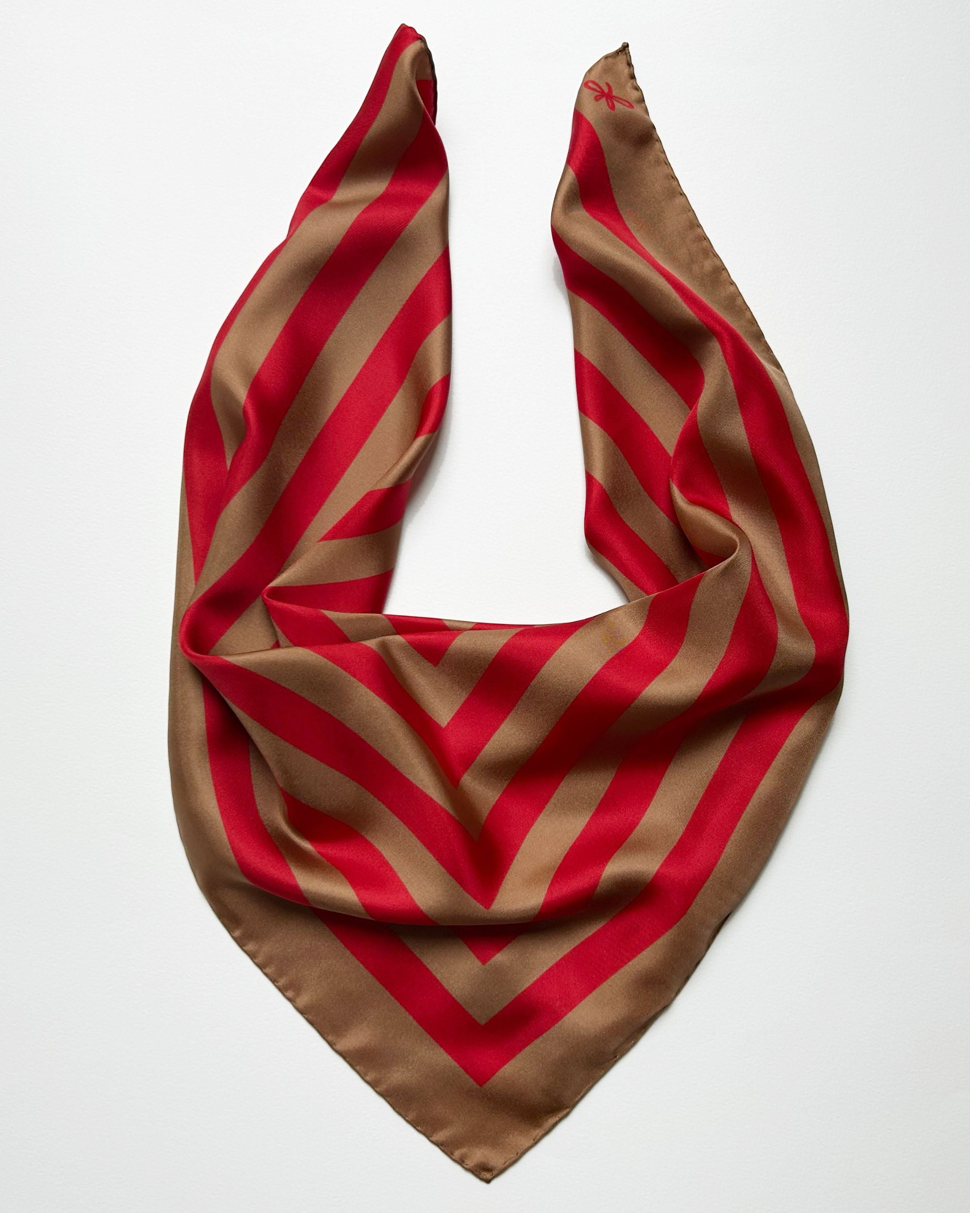 Square red and beige striped silk scarf laid flat
