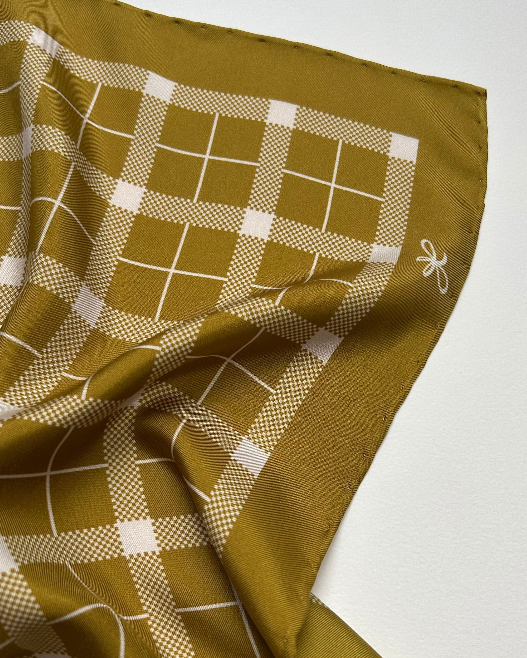 Mustard tartan silk scarf detail showing hand-rolled edge
