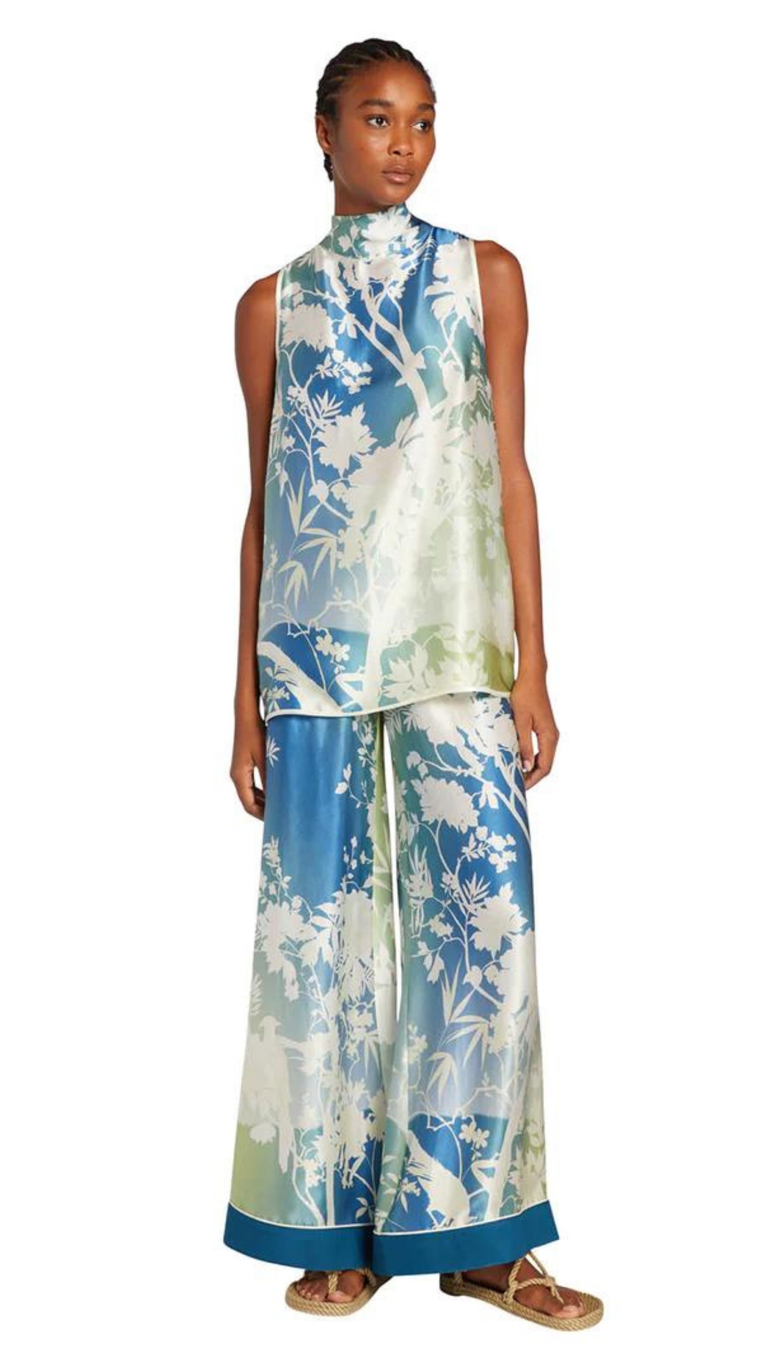 For Restless Sleepers Carcino Top. Sleeveless style in silk with blue and green tones. Japanese floral pattern in whire. Long style with adjustable scarf neckline. Shown on model facing front with coordinating Callisto Pants.