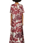 For Restless Sleepers Criso Dress PICTORIAL TREES IVORY BORDEAUX. Silk loose fitting a-line dress with half sleeves. Midi dress with burgundy trim at neck, sleeves and hemline. Shown on model facing back.