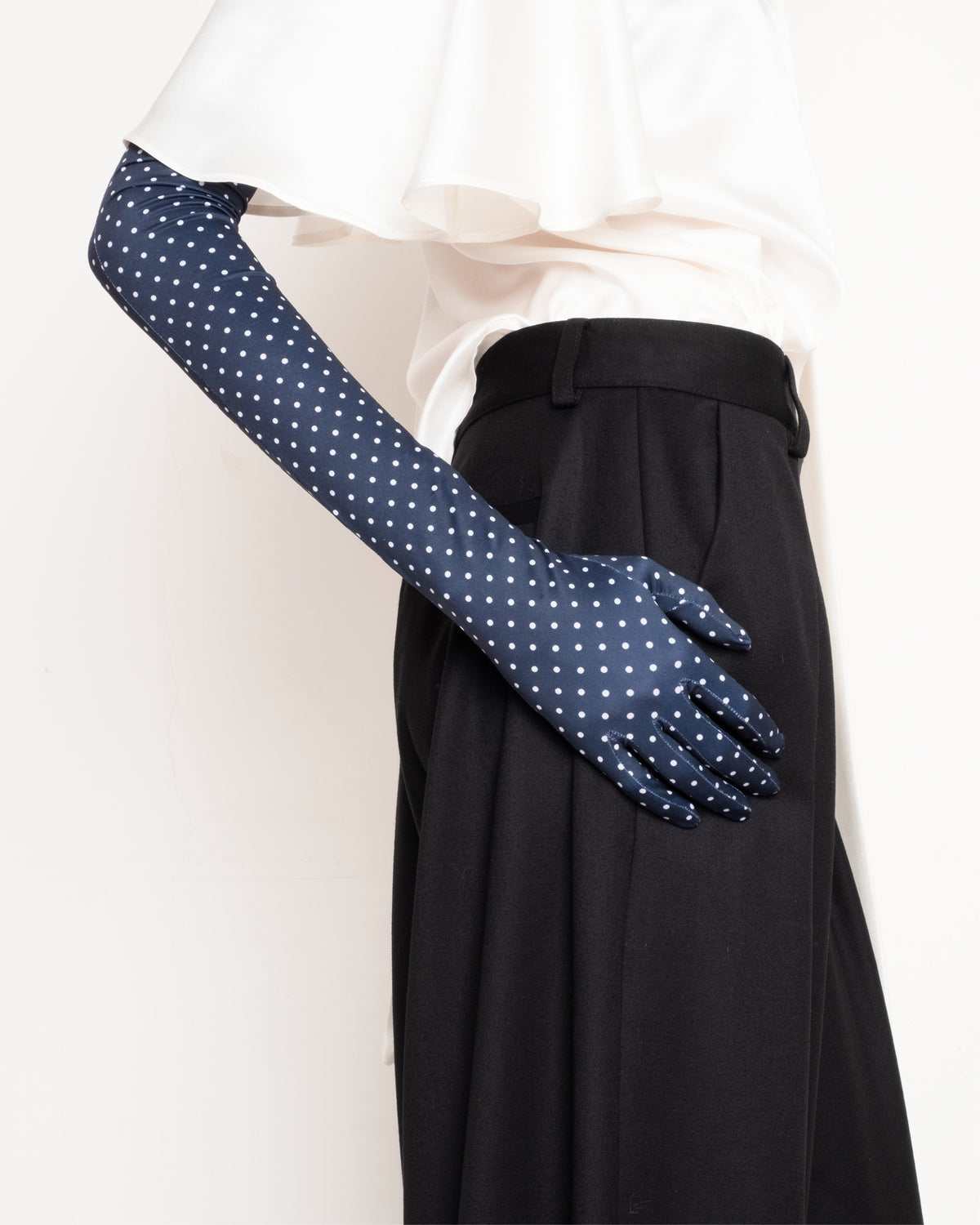 Françoise Agnes Gloves in navy polka dot, close-up detail on model with black trousers and white blouse