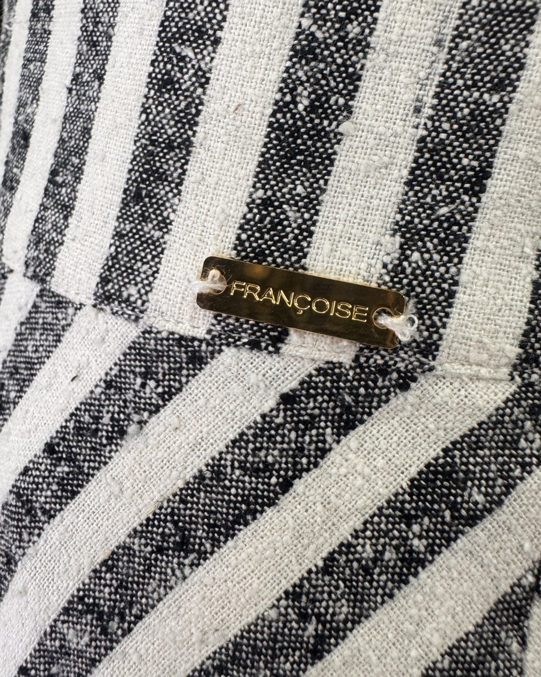 Françoise gold logo label on striped raw silk fabric