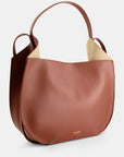 Ree Projects Helen Hobo in Cognac Soft Calf. Medium sized hobo style tote bag made from super soft italian leather. sustainably made in a cognac color. Shown from the front side view.