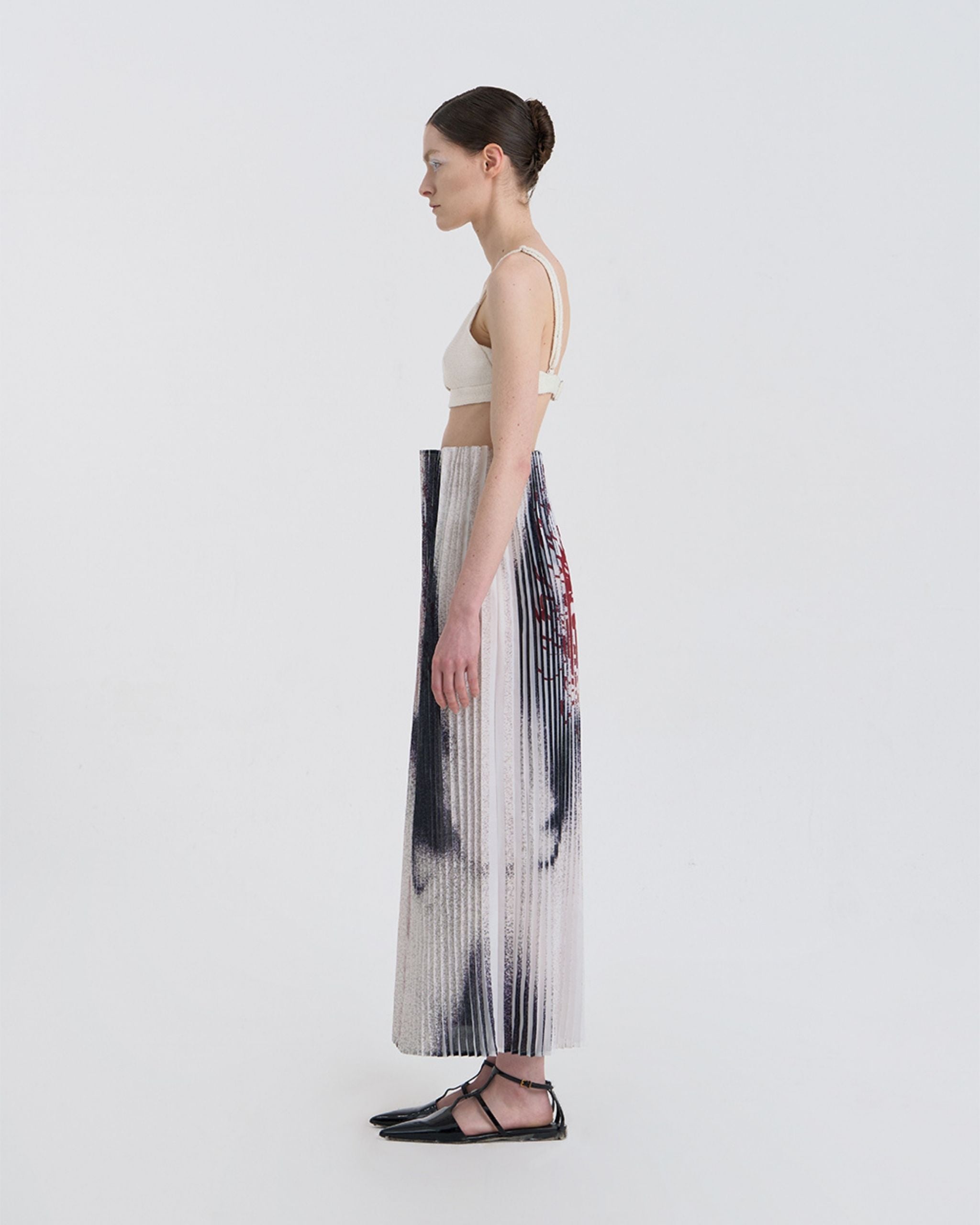 Side view of JINSUN Anamo Pleated Skirt showing soft vertical pleats and long silhouette.