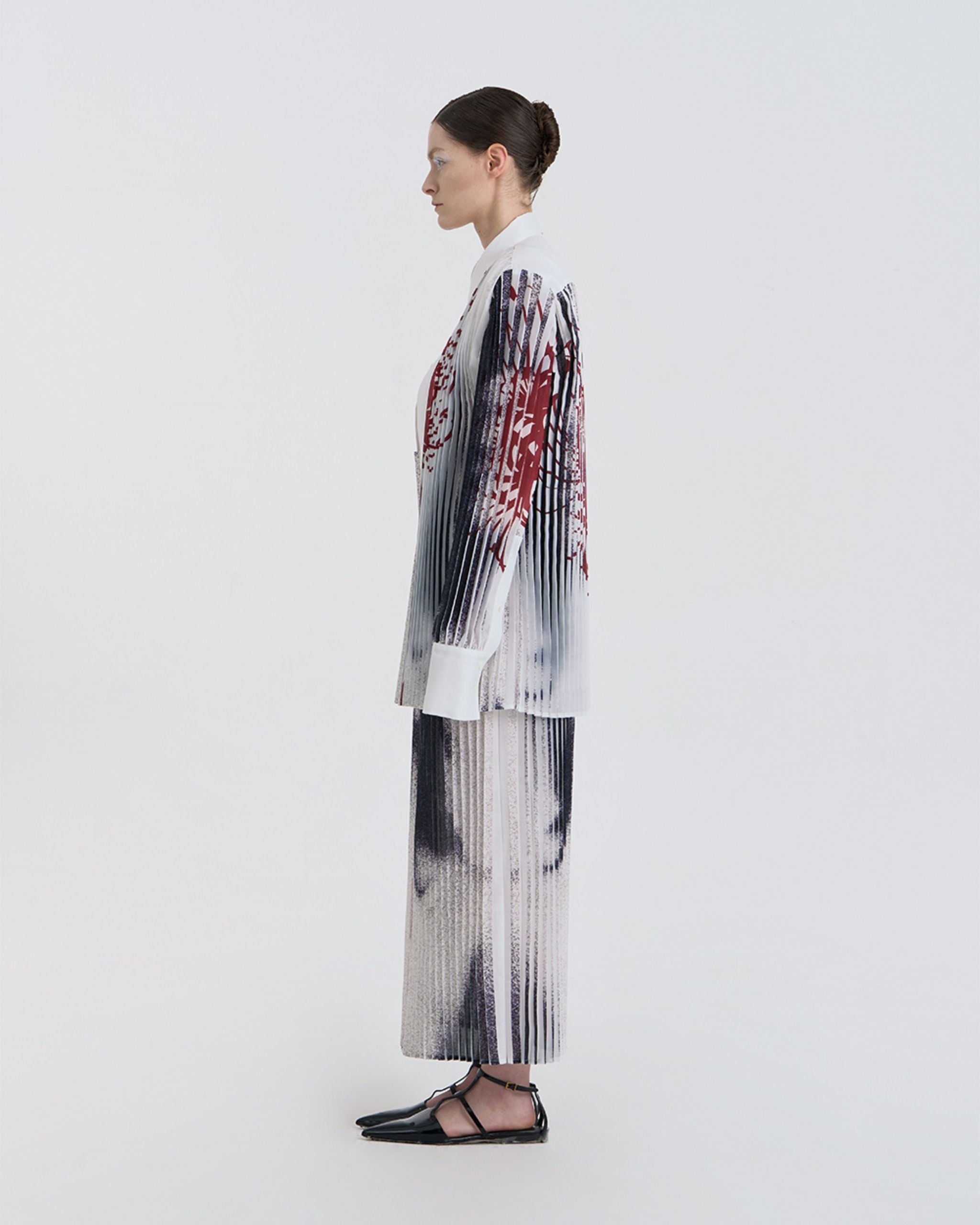 Side view of JINSUN Anamo Printed Shirt showing long silhouette and draped pleats