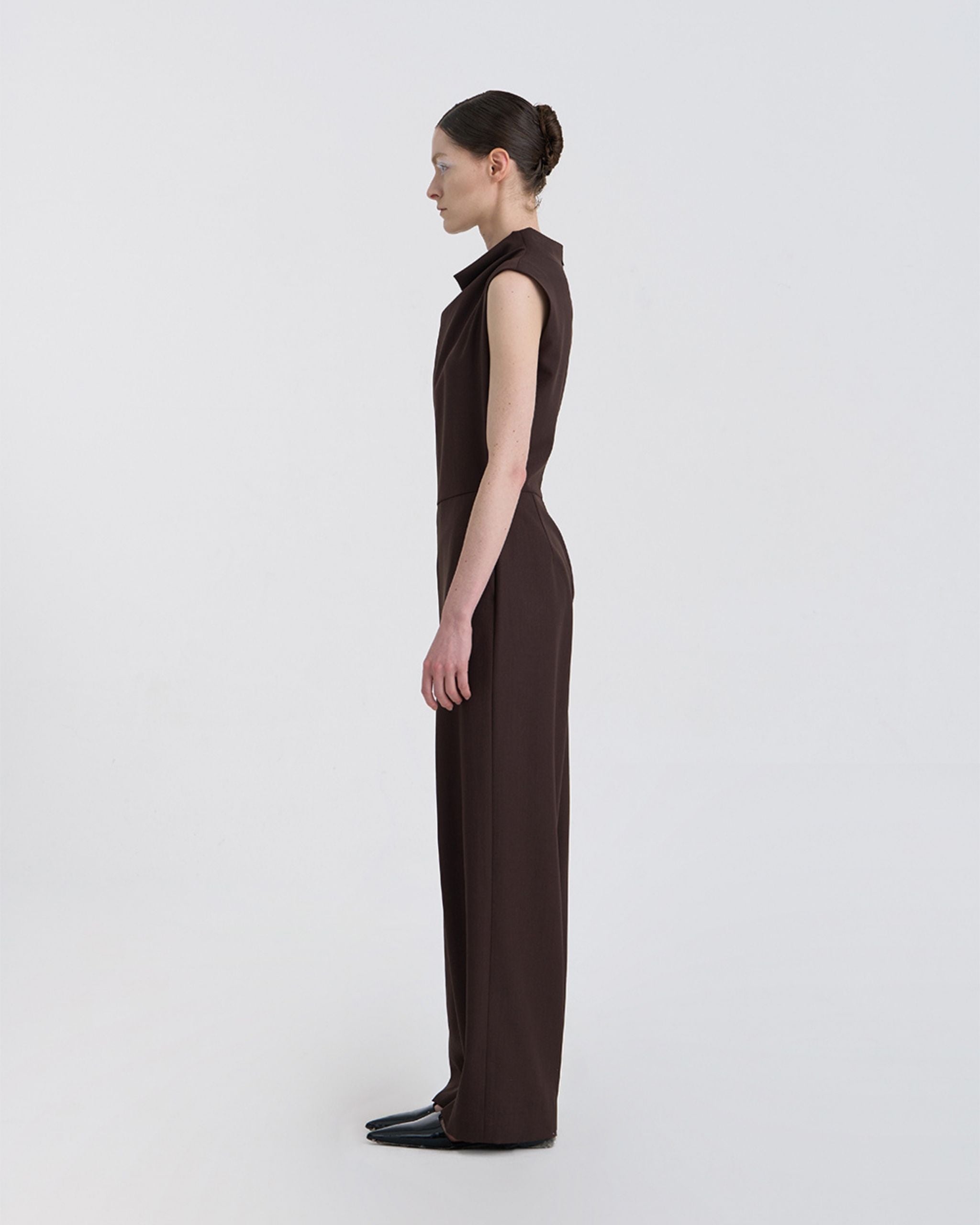 Side profile showing clean tailored lines of JINSUN Filante Wool Jumpsuit in brown