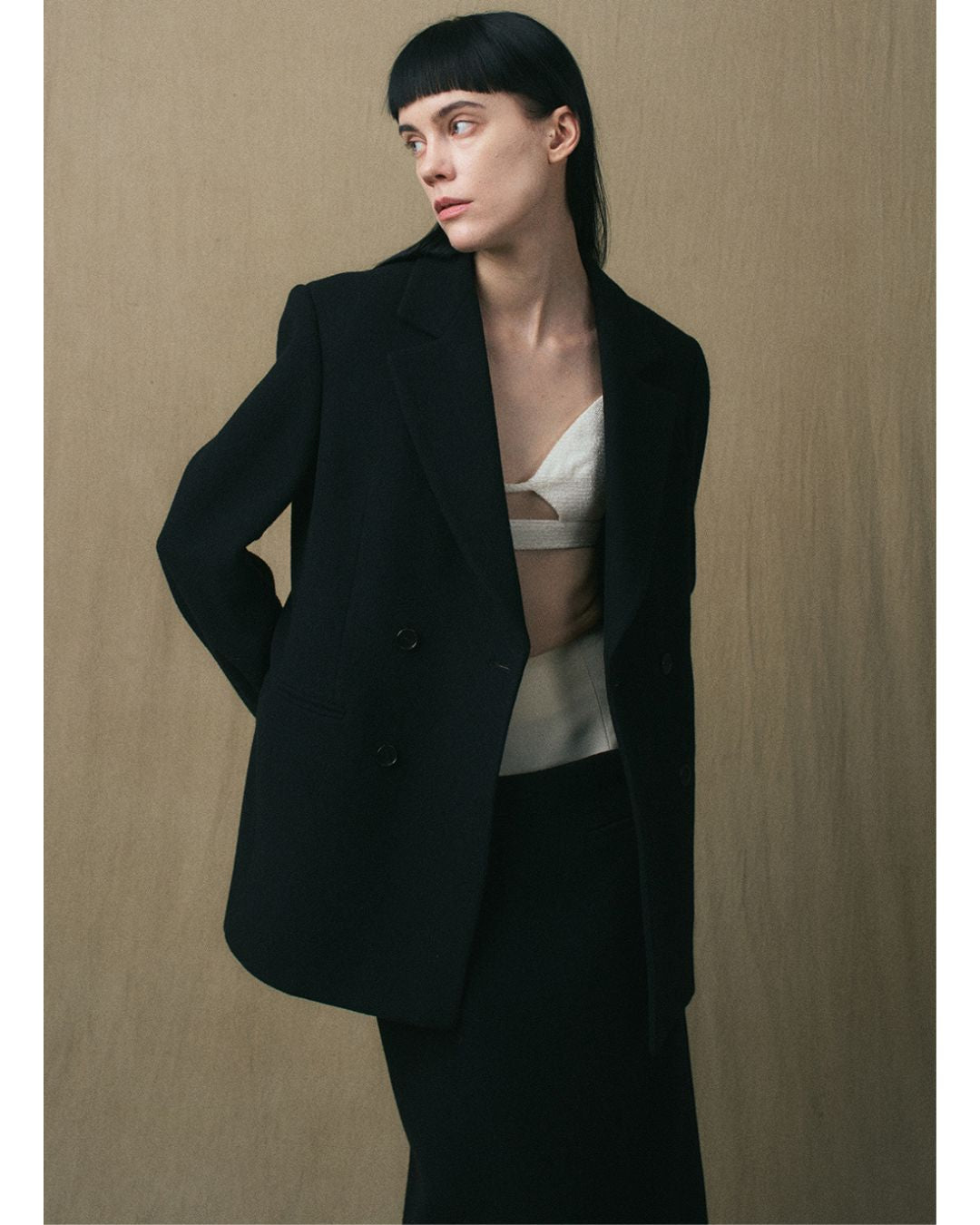 JINSUN Double-Breasted Wool Jacket in black styled open with the matching maxi skirt