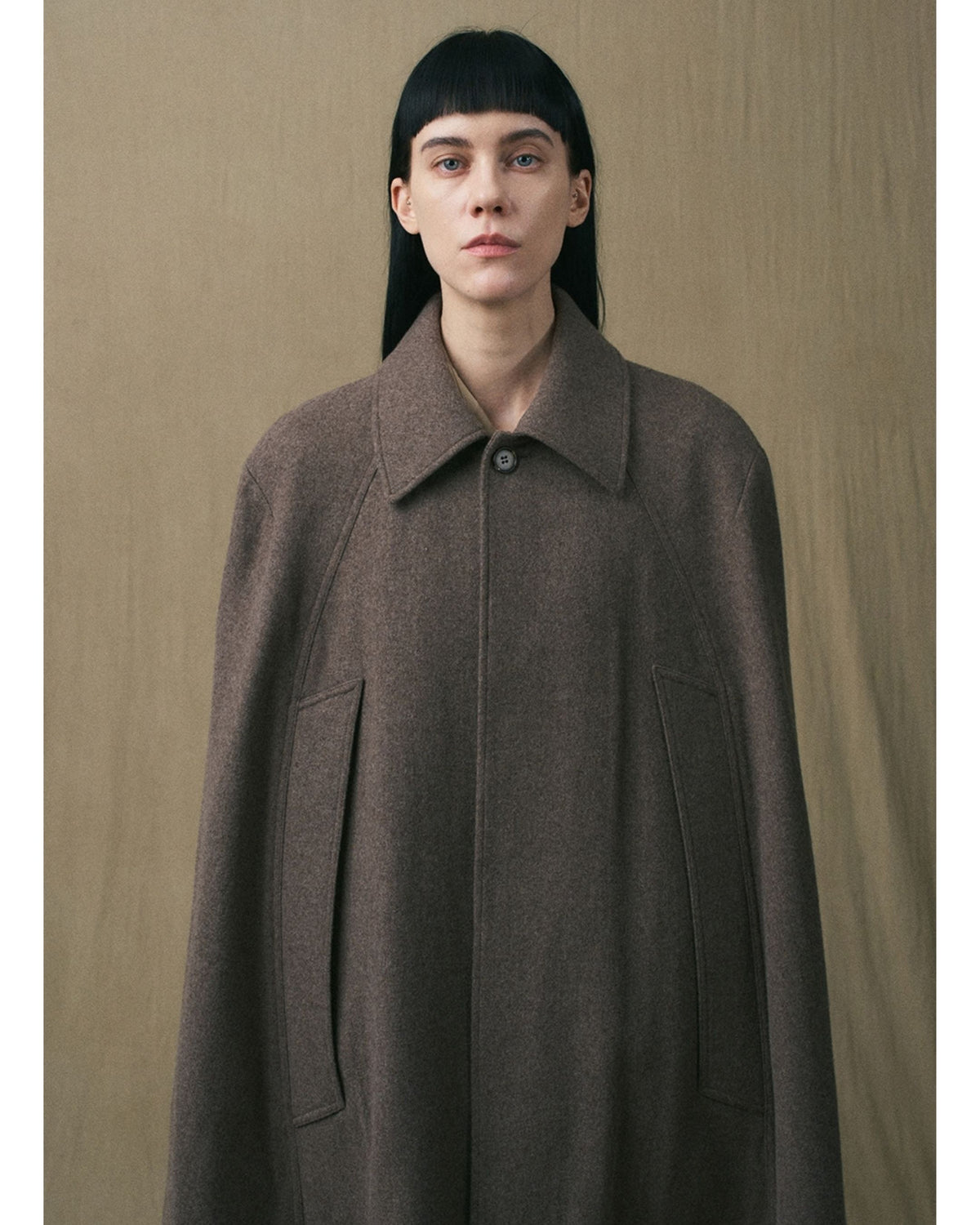 Close-up of the collar and concealed fastening on the brown wool cape coat