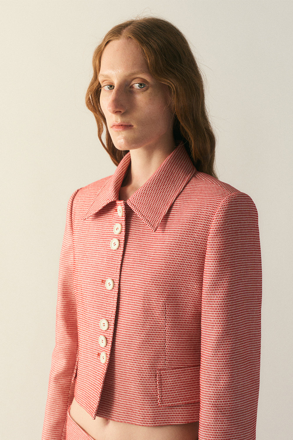 Detail view of wool–silk fabric texture and button closure
