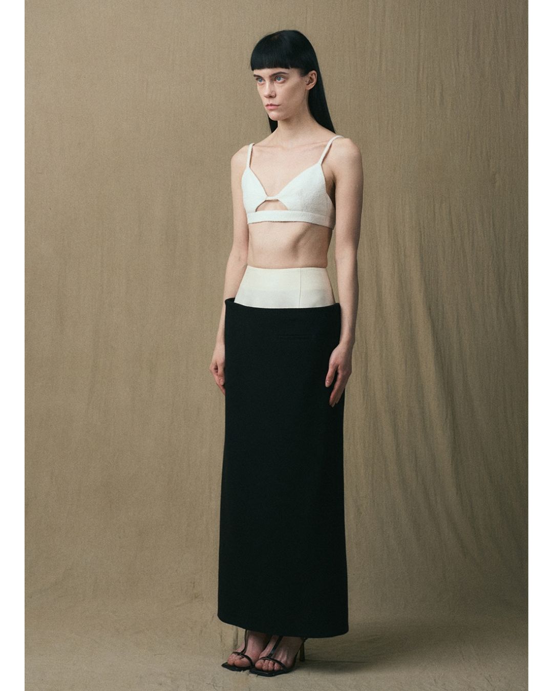 Three-quarter view of the JINSUN Tuxedo Maxi Pencil Skirt in black and ivory
