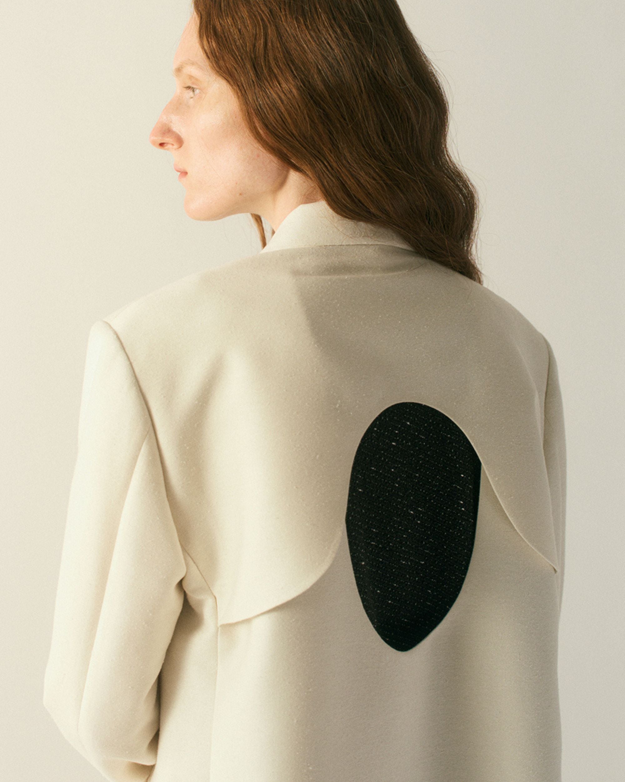 Back view of the Veyra Wool Silk Jacket in cream with sculptural back cut-out
