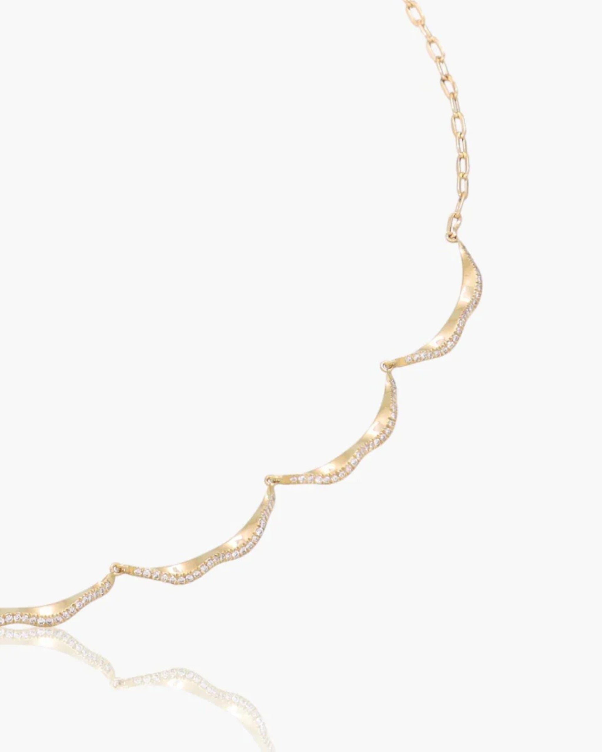 Close-up detail of the gold and diamond curved segments on the Plain Serene Necklace.