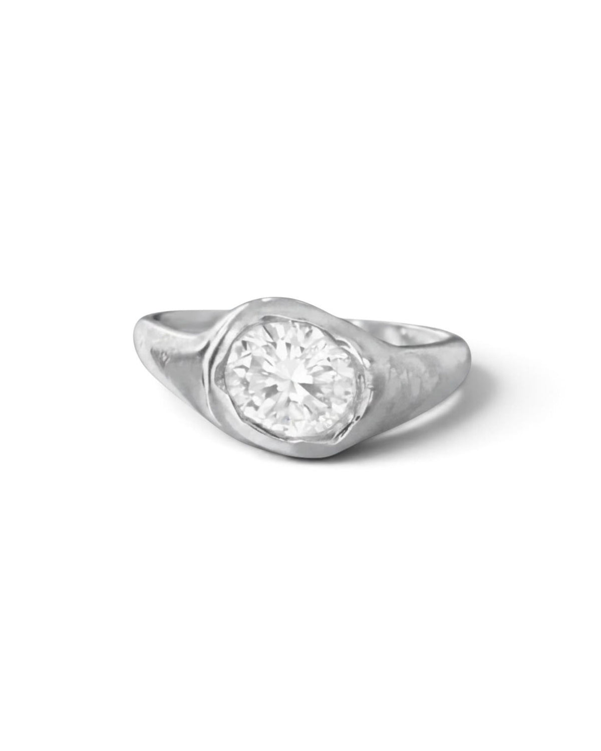  Sterling silver ring with a round lab-created white stone resting on brown tissue paper