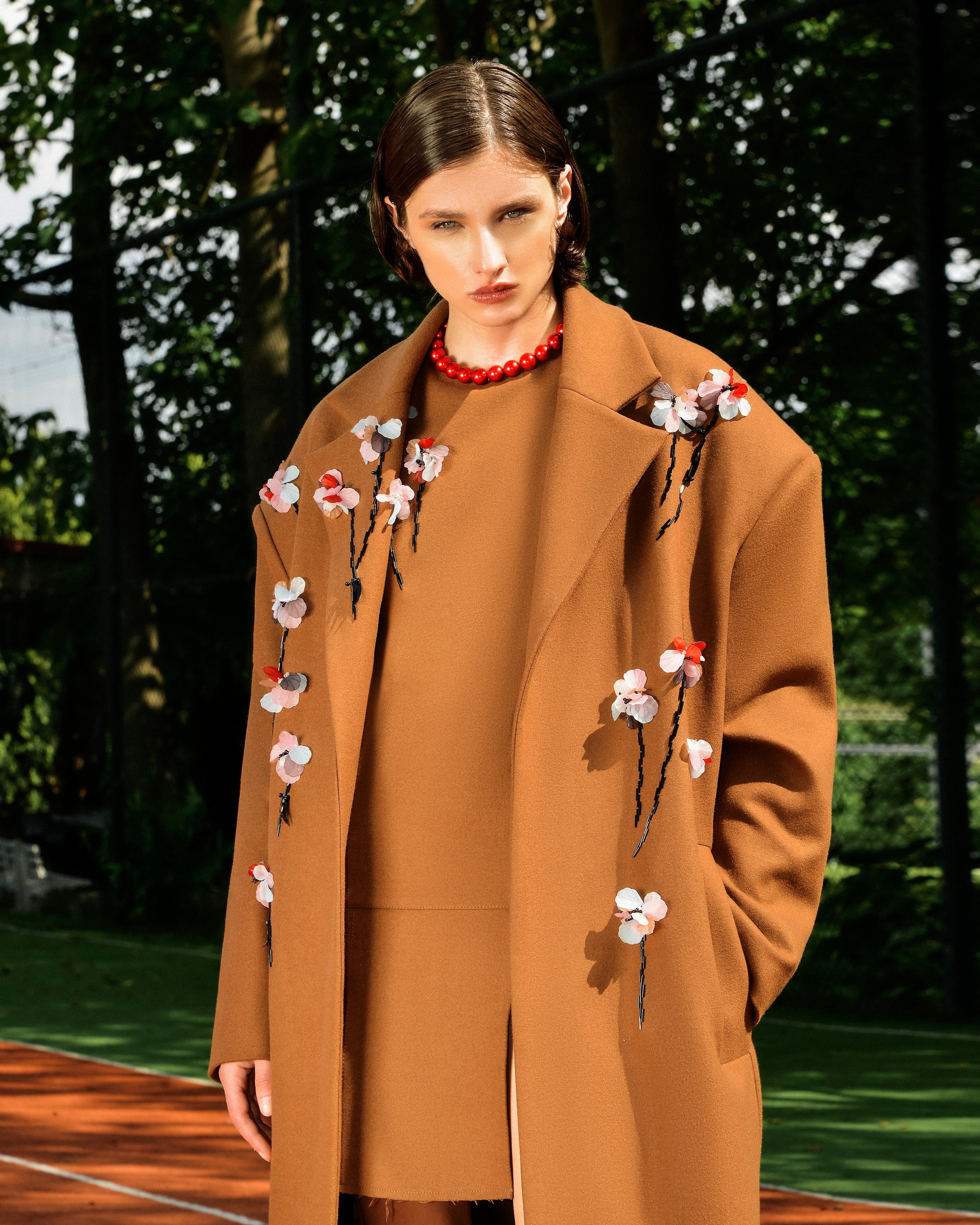 Detail view of hand-applied floral embellishments on the Floris Coat
