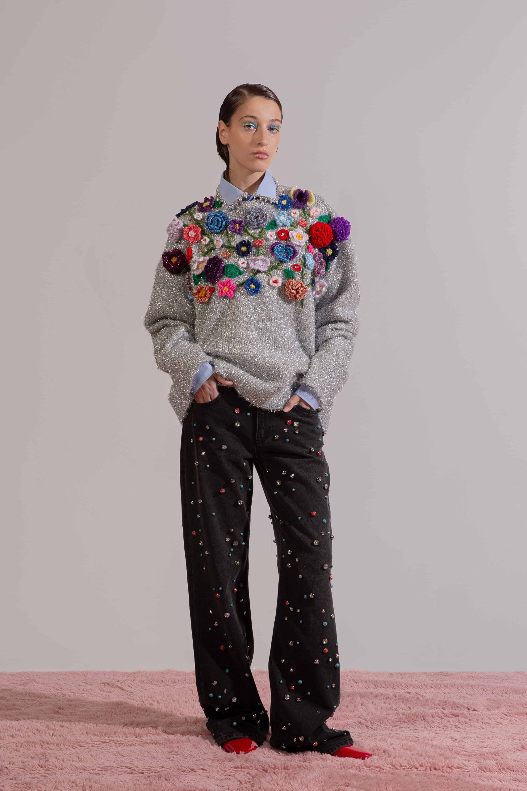 Detail view of crochet floral embellishment on knit fabric