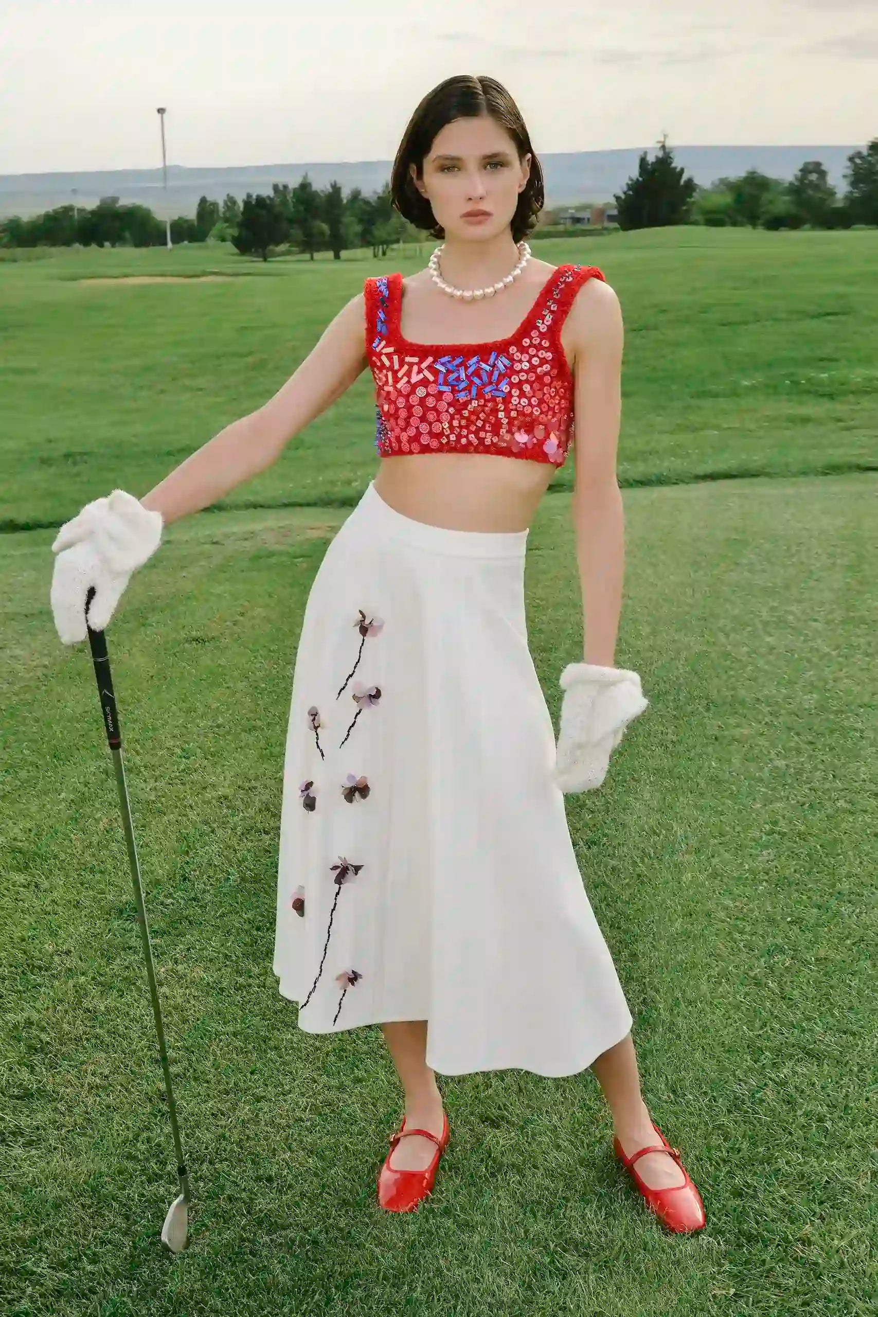 Model wearing the Floris Skirt styled with a cropped top on a golf course