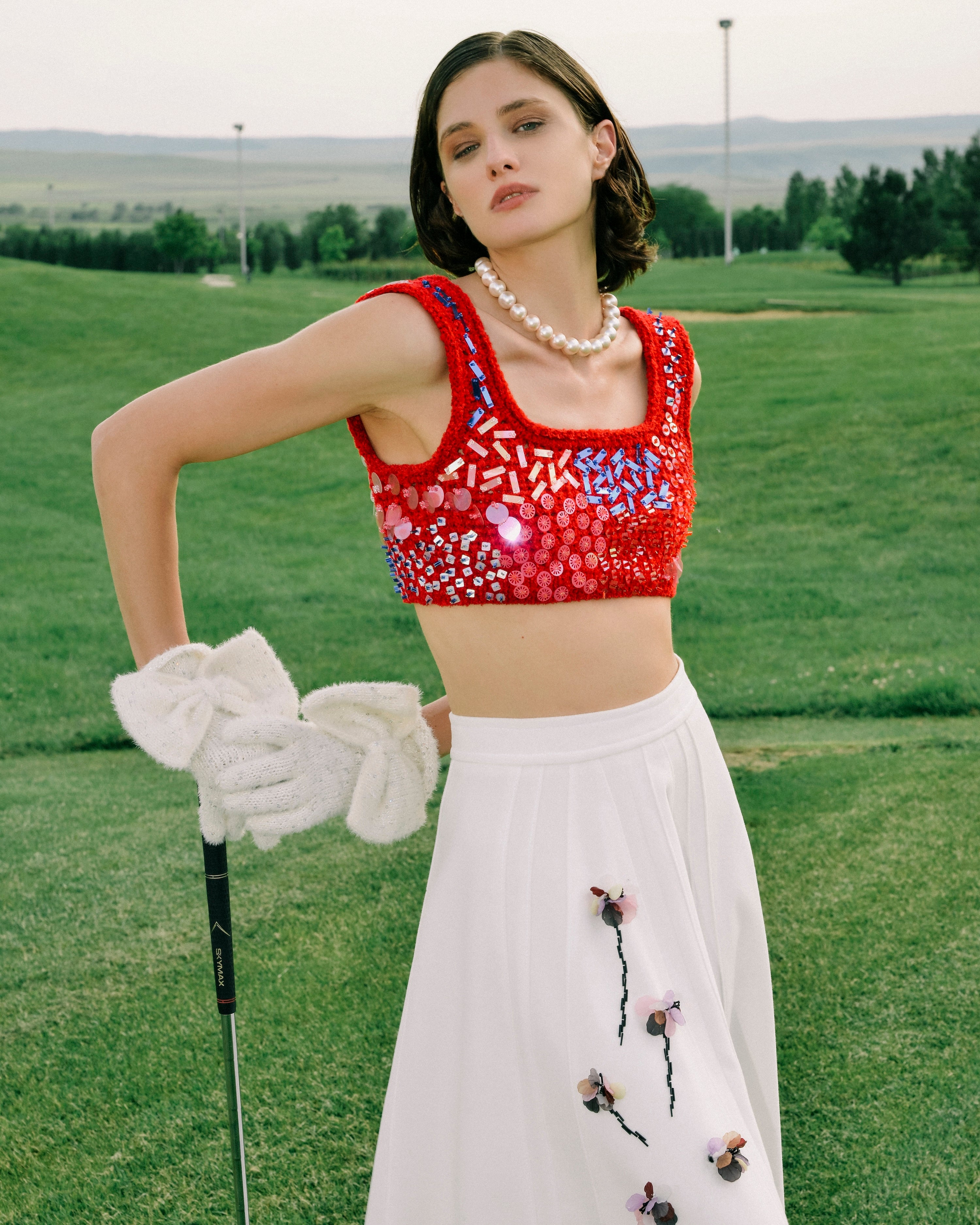 Model wearing the Floris Skirt styled with a cropped top on a golf course