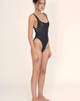 Leslie Amon Cindy One Piece in Black and White Dots. Classic style one piece with a slightly high leg and open scoop neck back. Made from jacquard fabric in black and white polka dots. Shown on model facing the front.