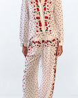 Leslie Amon Oversized Shirt in White Cherry. Oversized blouse in white with red cherry pattern. With button closures up the front, buttoned cuffs and collar. Photo shown on model facing front.