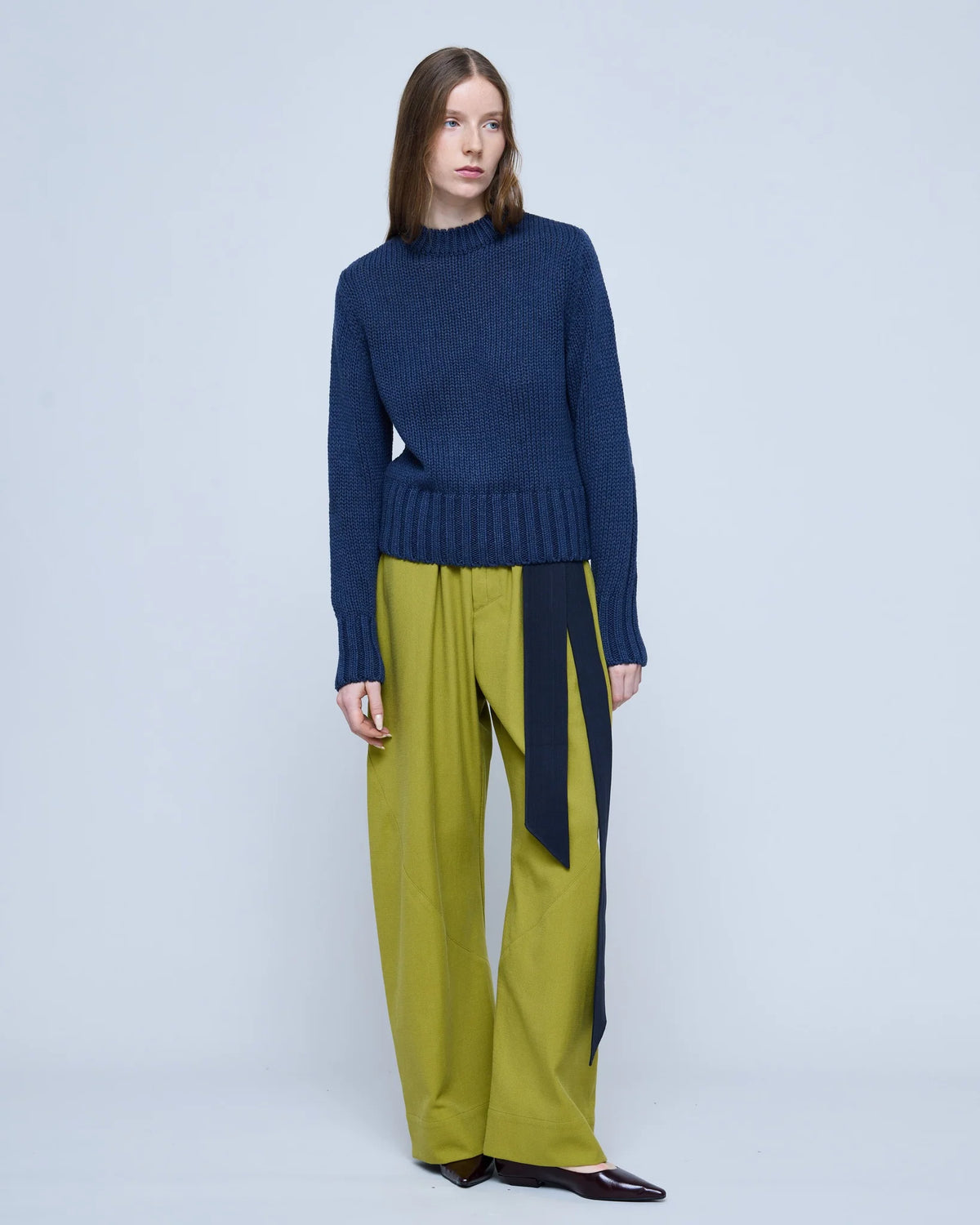 Full-length front view of the MARTAN Floyd Sweater in anthracite blue, styled with lime trousers