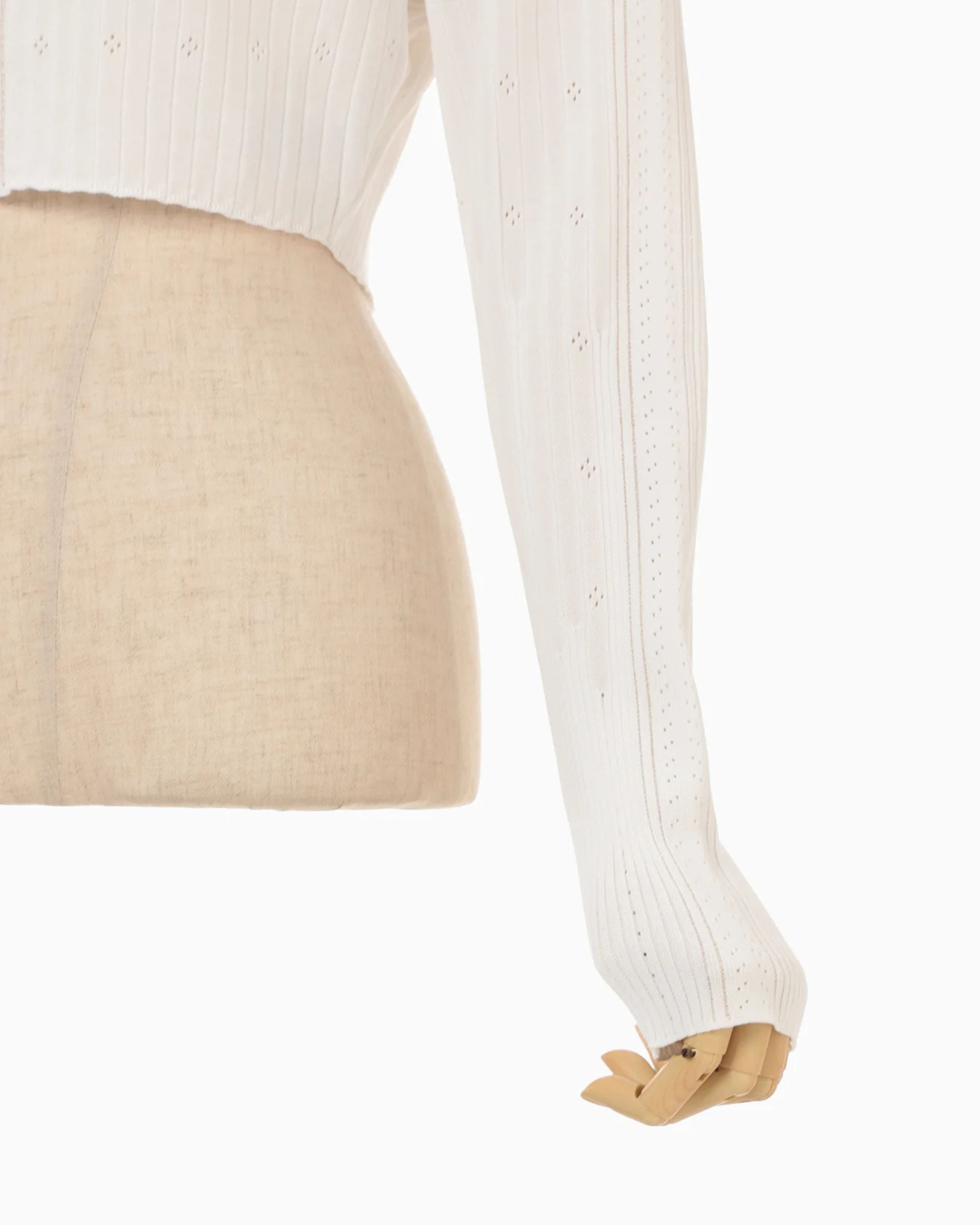 Mame Kurogouchi Ribbed Eyelet Knit Long Sleeve Top in White — detail view of sleeve and cropped hem