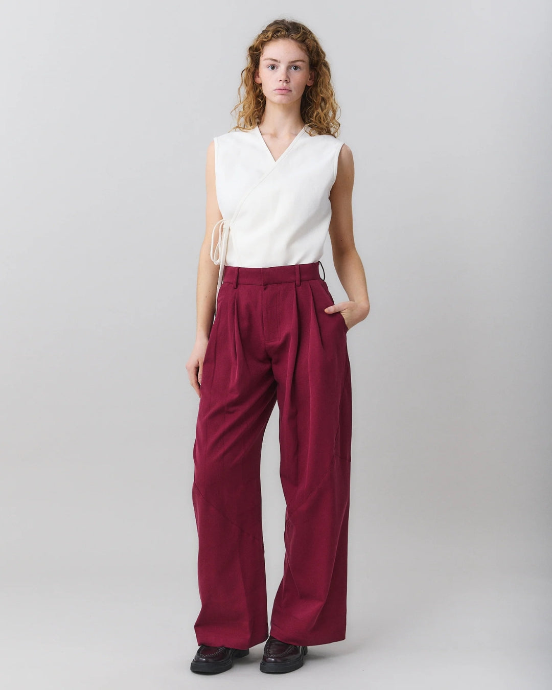 MARTAN Jo Trousers in plum purple, full length front view on model styled with white wrap top