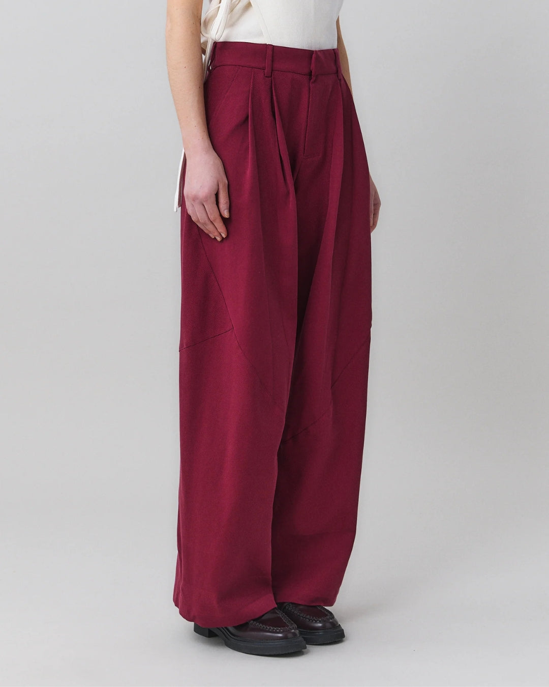 Close three-quarter view of MARTAN Jo Trousers showing pleat volume and leg width