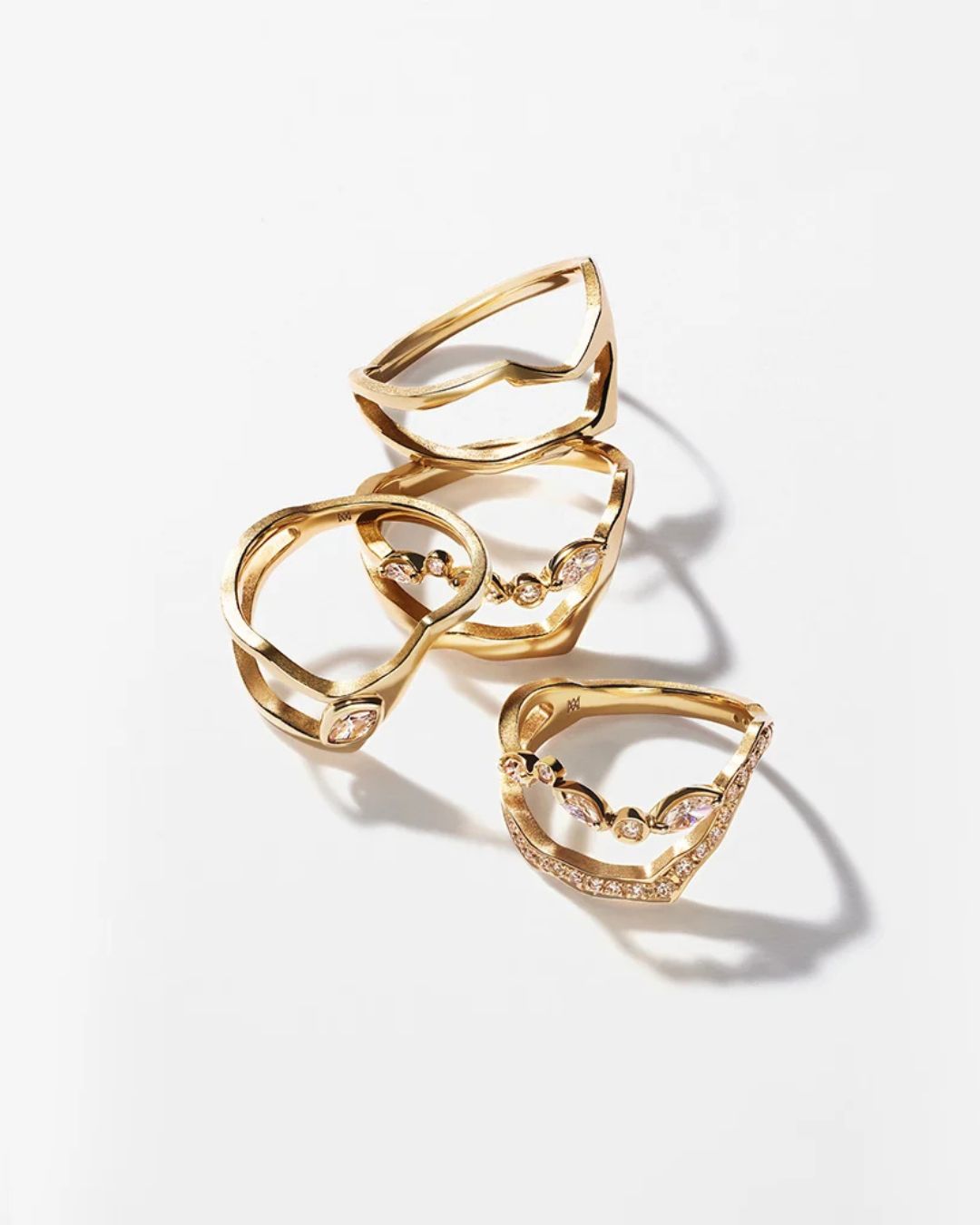 Selection of Milamore Kintsugi rings in 18K yellow gold arranged on a white background