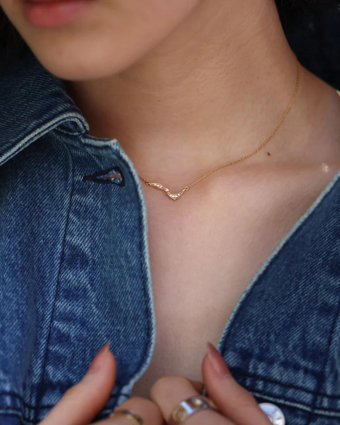 1. Milamore Kintsugi Mini Pavé Necklace worn at the collarbone with a denim jacket.