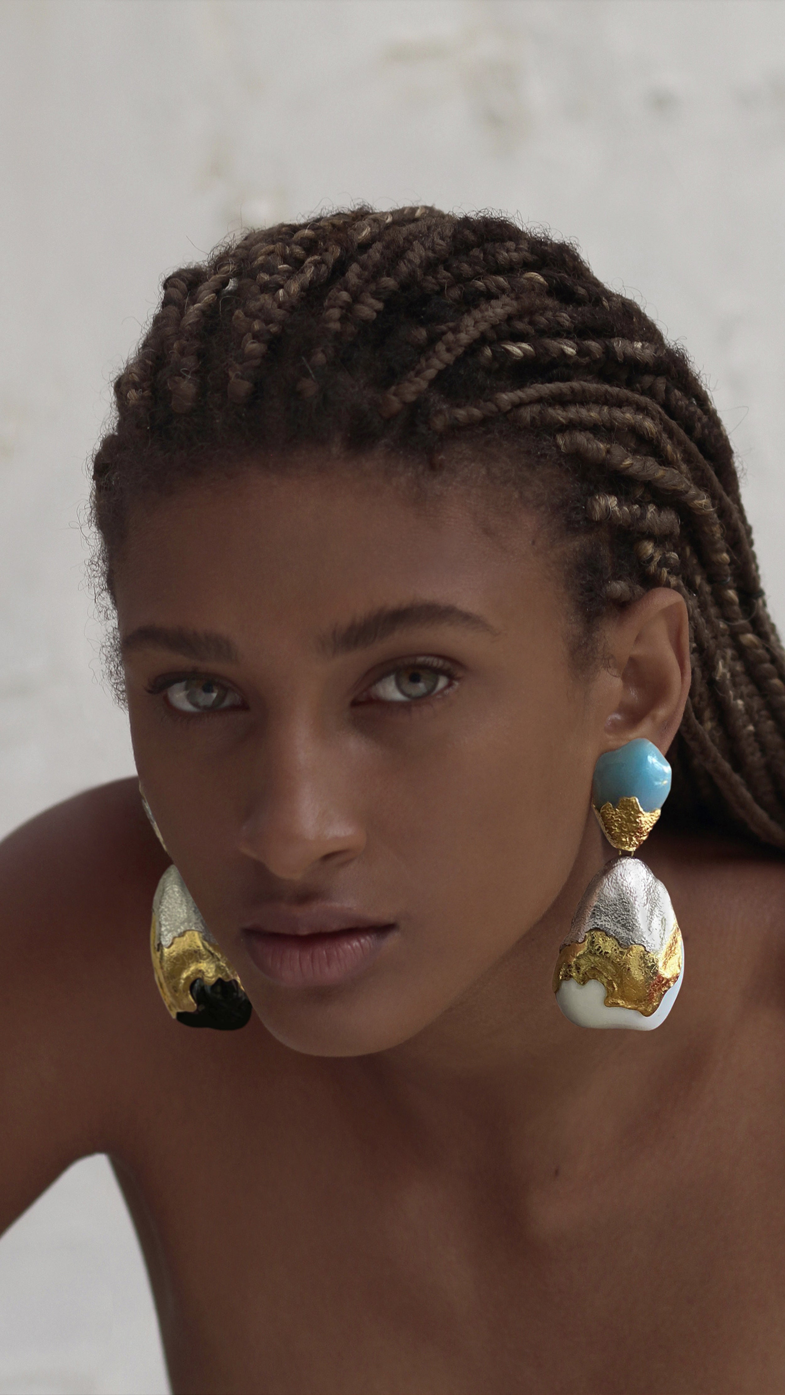 Monica Sordo, Araya Long Earrings. organic shaped drop earrings feature 24 carat gold with stunning Black Onyx, White Onyx, and Angelite stones. Sustainable designer jewelry, fair trade jewelry. Photo of earrings on model.